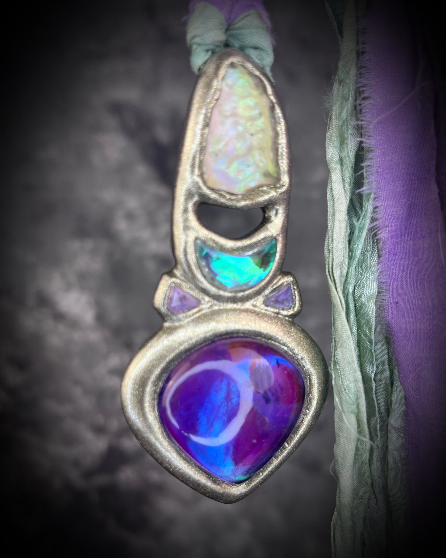 Libyan Desert Glass talisman with amethyst, prasiolite and lavender spinel on recycled silk, featuring shifting green, gold, pink and purple glow. Handmade by Become Spellbound.