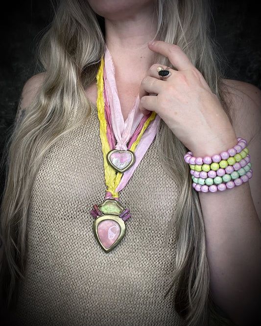 Libyan Desert Glass talisman with raw ruby crystals, rose quartz, and pink and yellow recycled silk ties by Become Spellbound, Baltimore Magazine Best of Baltimore 2026 Jewelry winner.