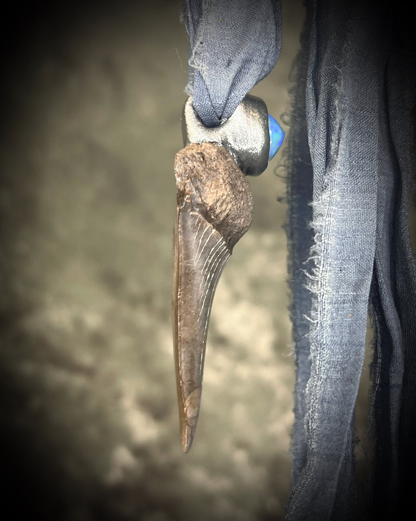 Mako shark tooth and opal fossil pendant on grey recycled silk. Side View