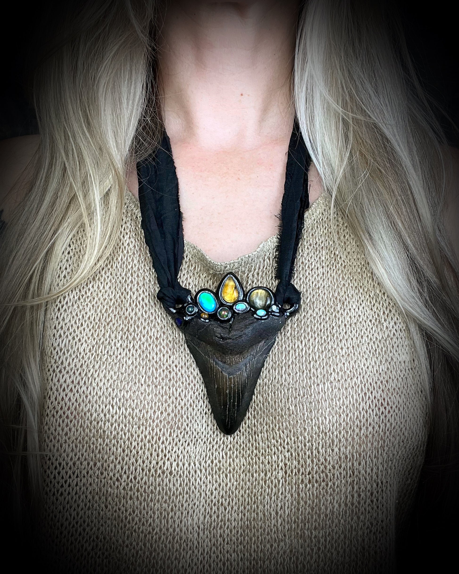 Megalodon crystal talisman necklace displayed on model with recycled silk ties — artisan fantasy statement jewelry.
