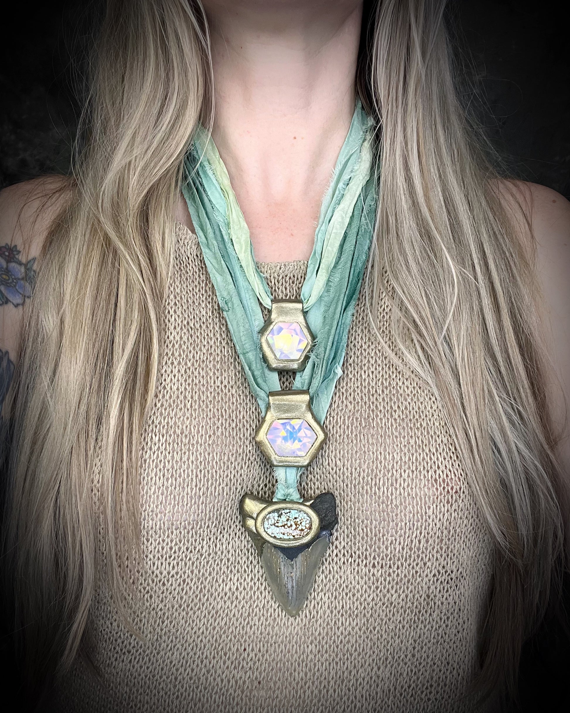 Megalodon fossil shark tooth talisman with aqua turquoise crystal, handmade shark tooth necklace on sea green recycled silk. Shown here layered with opalescent quartz necklaces. 
