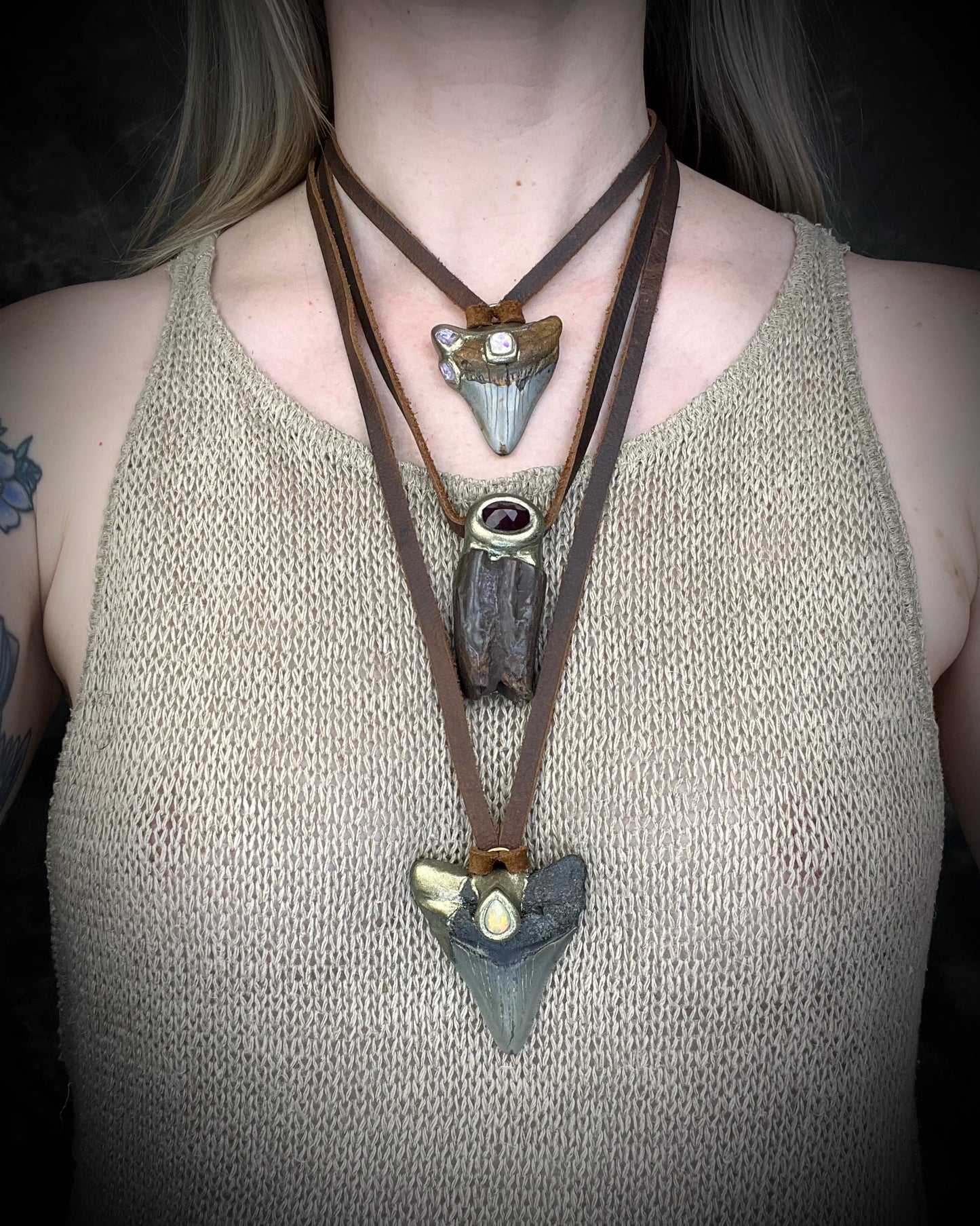 Megalodon shark tooth handmade necklace featuring a brilliant fiery pear cut opal gemstone. Worn here layered with other fossil and gemstone pendants. 