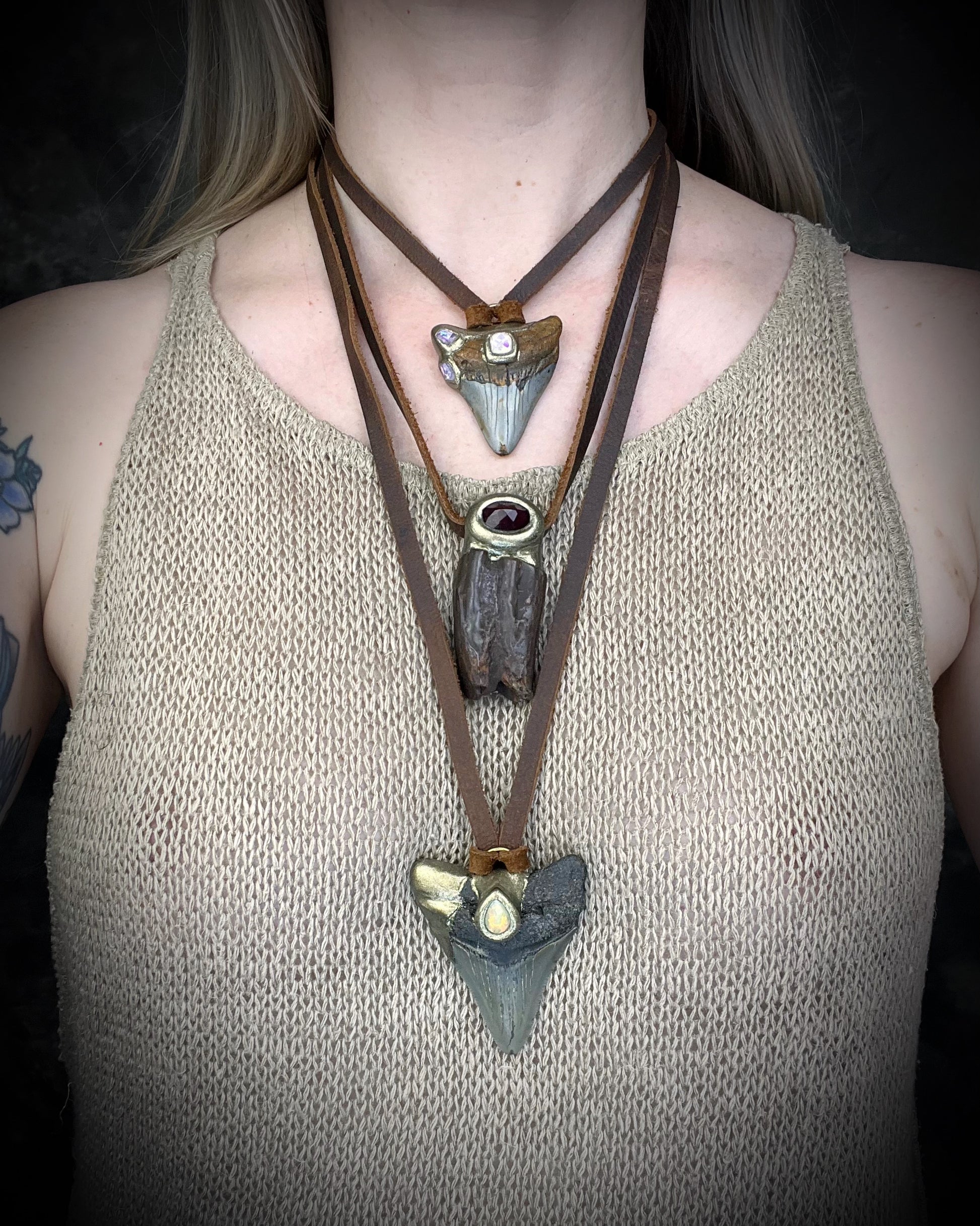 Megalodon shark tooth handmade necklace featuring a brilliant fiery pear cut opal gemstone. Worn here layered with other fossil and gemstone pendants. 