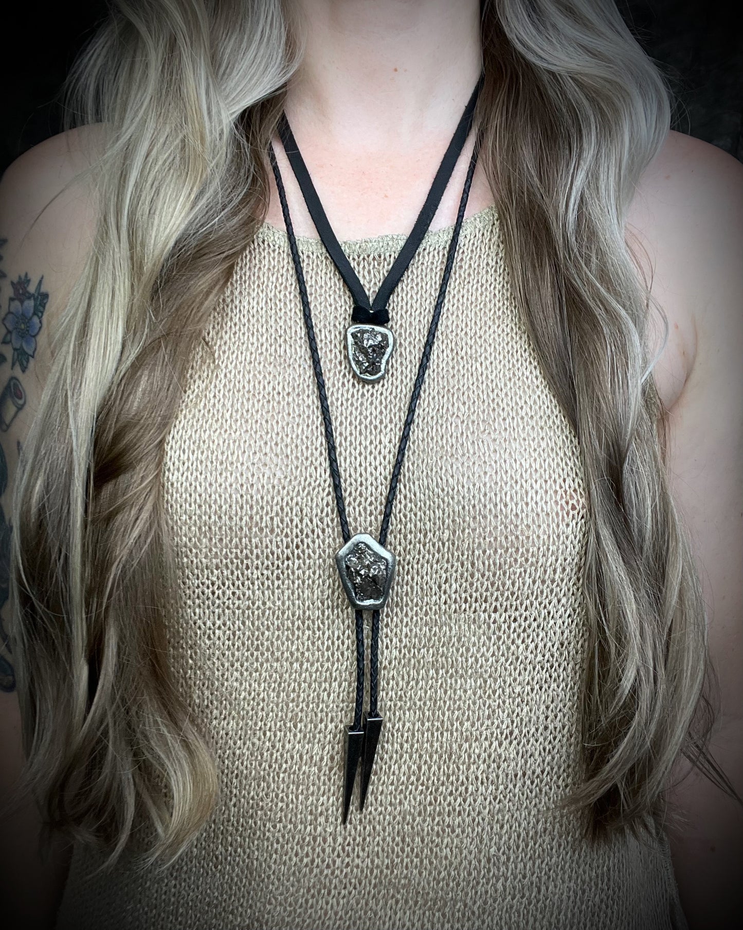 Meteorite bolo tie with gunmetal finish, black leather cord, and dramatic spike bolo tips, handmade by Become Spellbound in Baltimore, Maryland.
