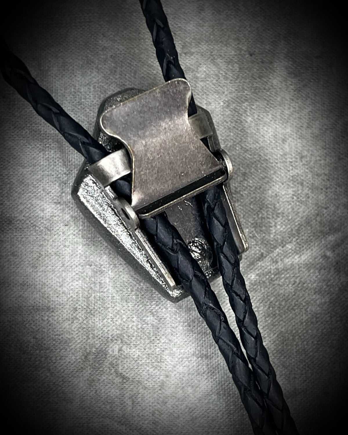Meteorite bolo tie with gunmetal finish, black leather cord, and dramatic spike bolo tips, handmade by Become Spellbound in Baltimore, Maryland.