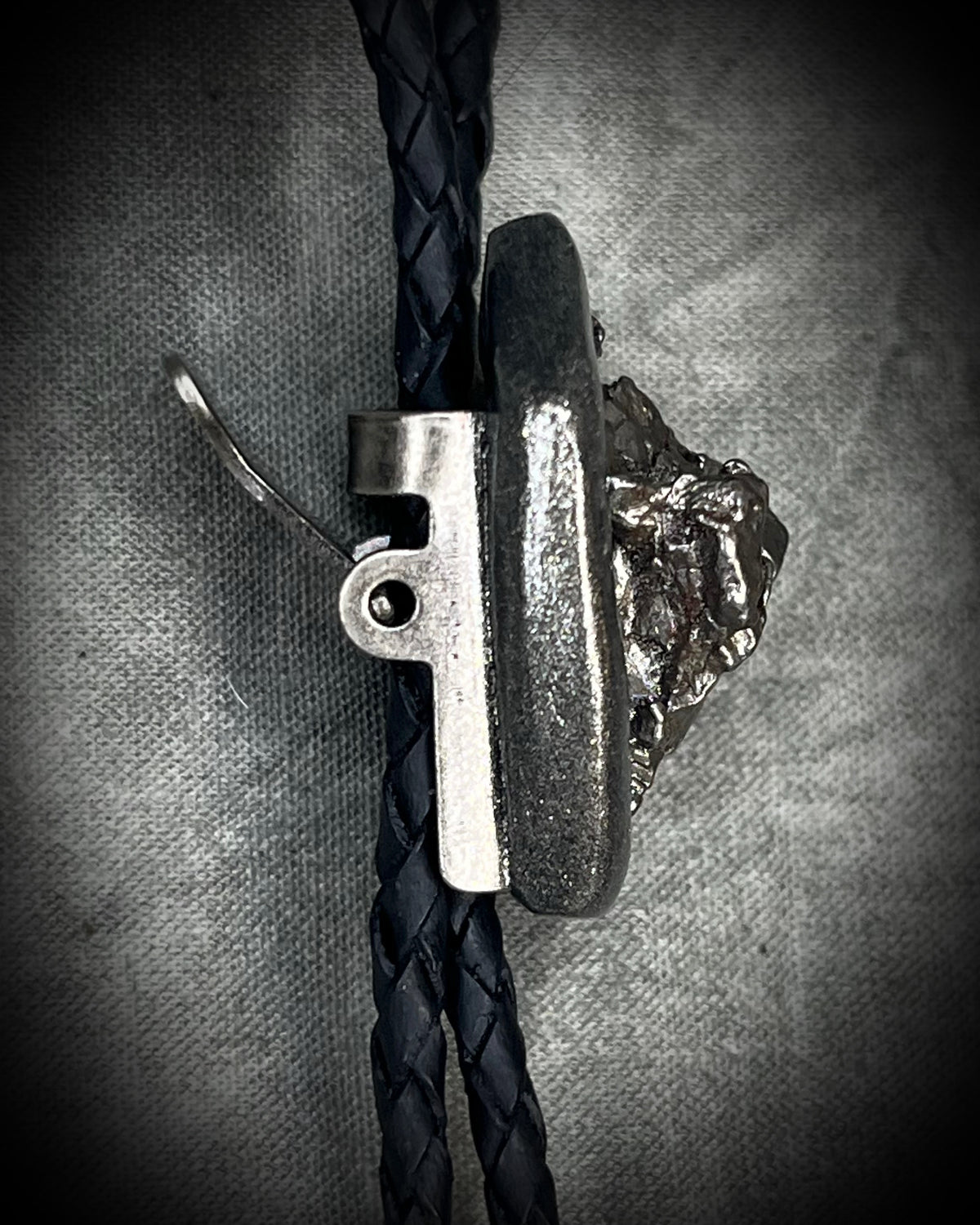 Meteorite bolo tie with gunmetal finish, black leather cord, and dramatic spike bolo tips, handmade by Become Spellbound in Baltimore, Maryland.