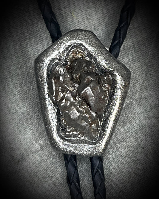 Meteorite bolo tie with gunmetal finish, black leather cord, and dramatic spike bolo tips, handmade by Become Spellbound in Baltimore, Maryland.