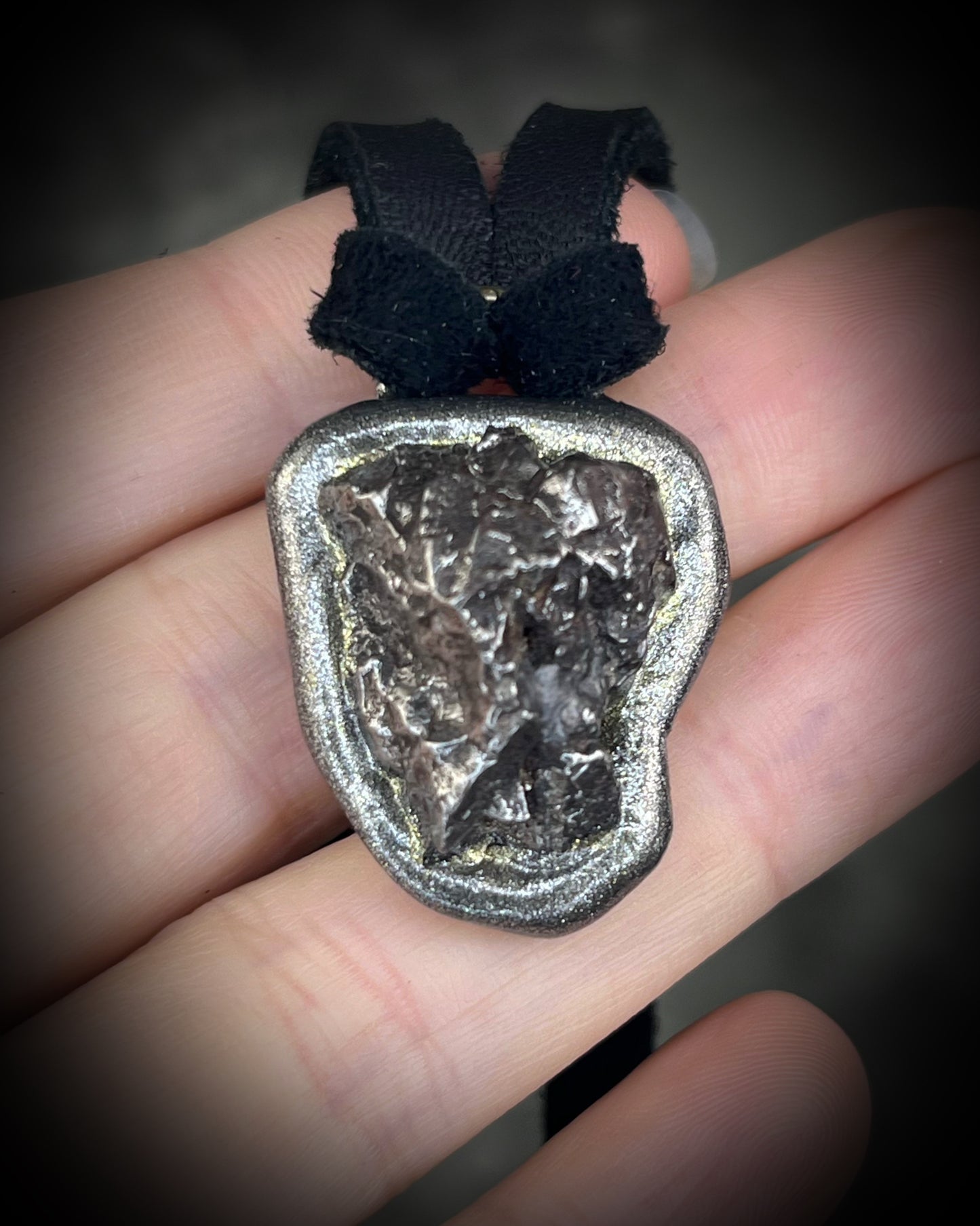 Meteorite talisman in gunmetal finish on black leather, cosmic statement jewelry handmade by Become Spellbound in Baltimore, Maryland.