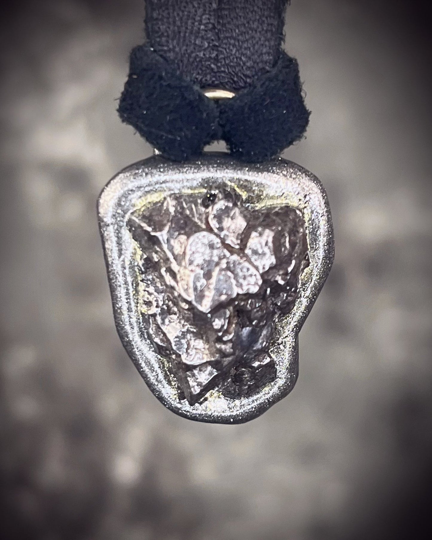 Meteorite talisman in gunmetal finish on black leather, cosmic statement jewelry handmade by Become Spellbound in Baltimore, Maryland.