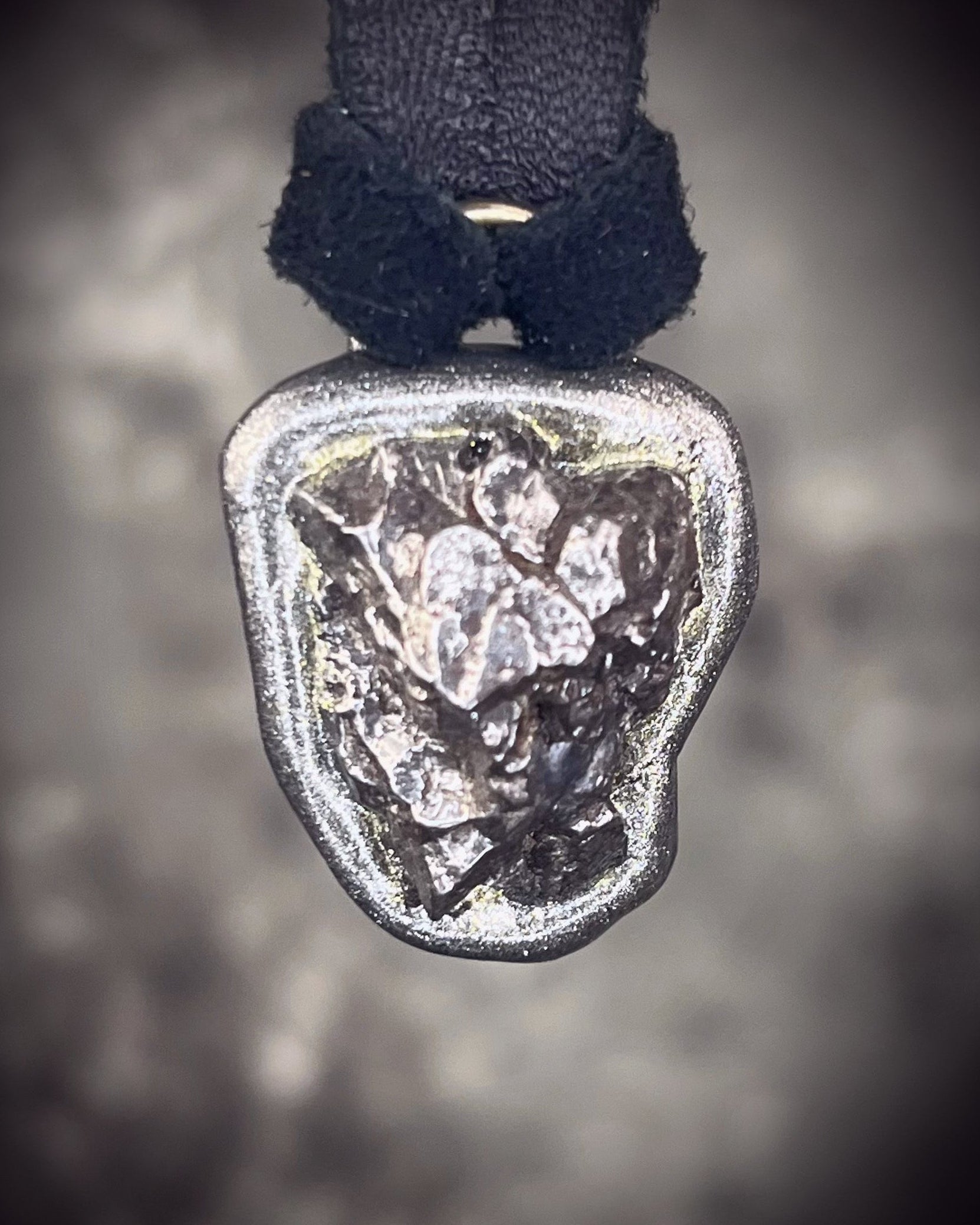 Meteorite talisman in gunmetal finish on black leather, cosmic statement jewelry handmade by Become Spellbound in Baltimore, Maryland.