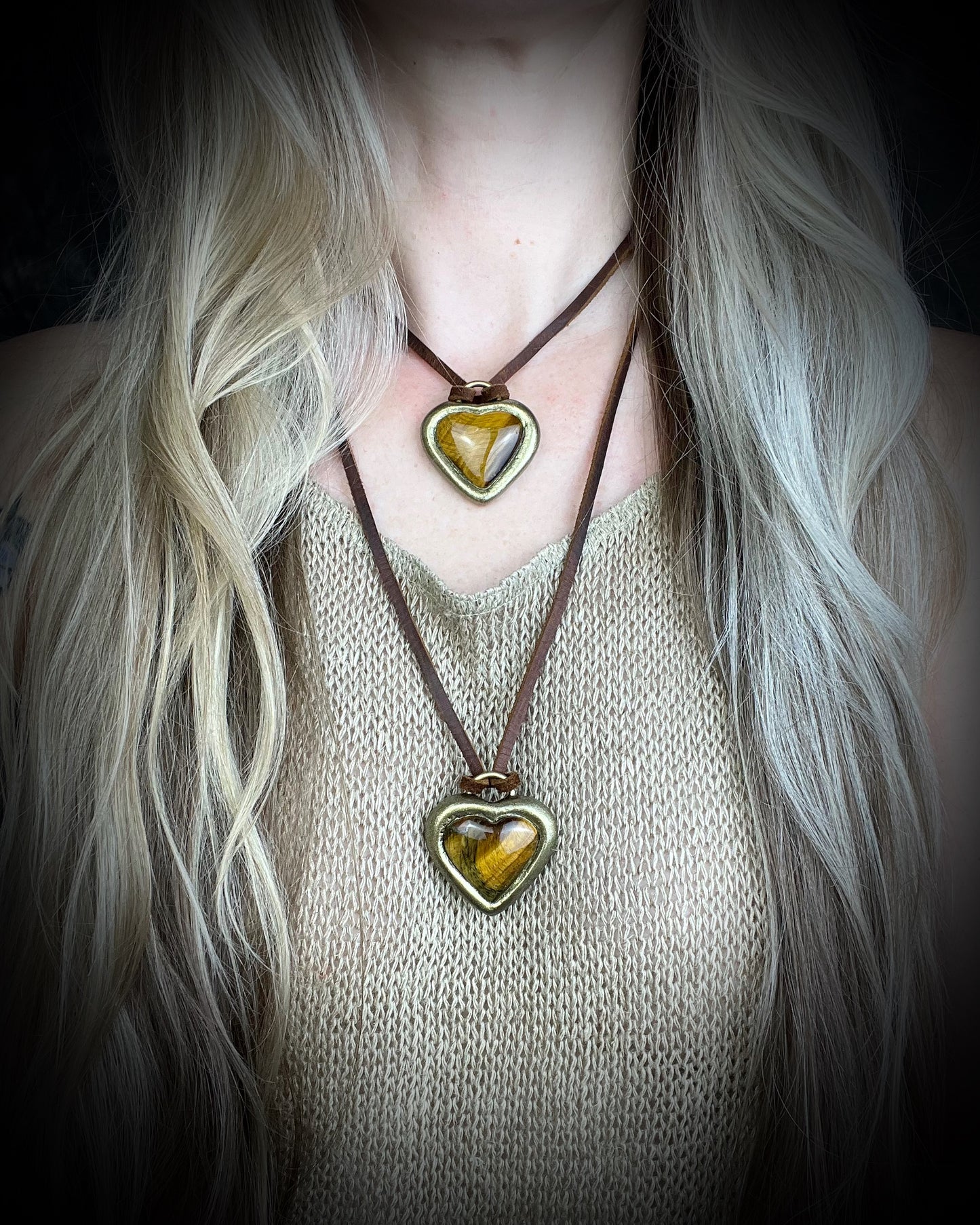 Model wearing layering necklaces- Tiger’s Eye crystal heart pendant necklaces with gold finish on brown leather cord — handmade grounding and protective jewelry. Holiday gift for her.
