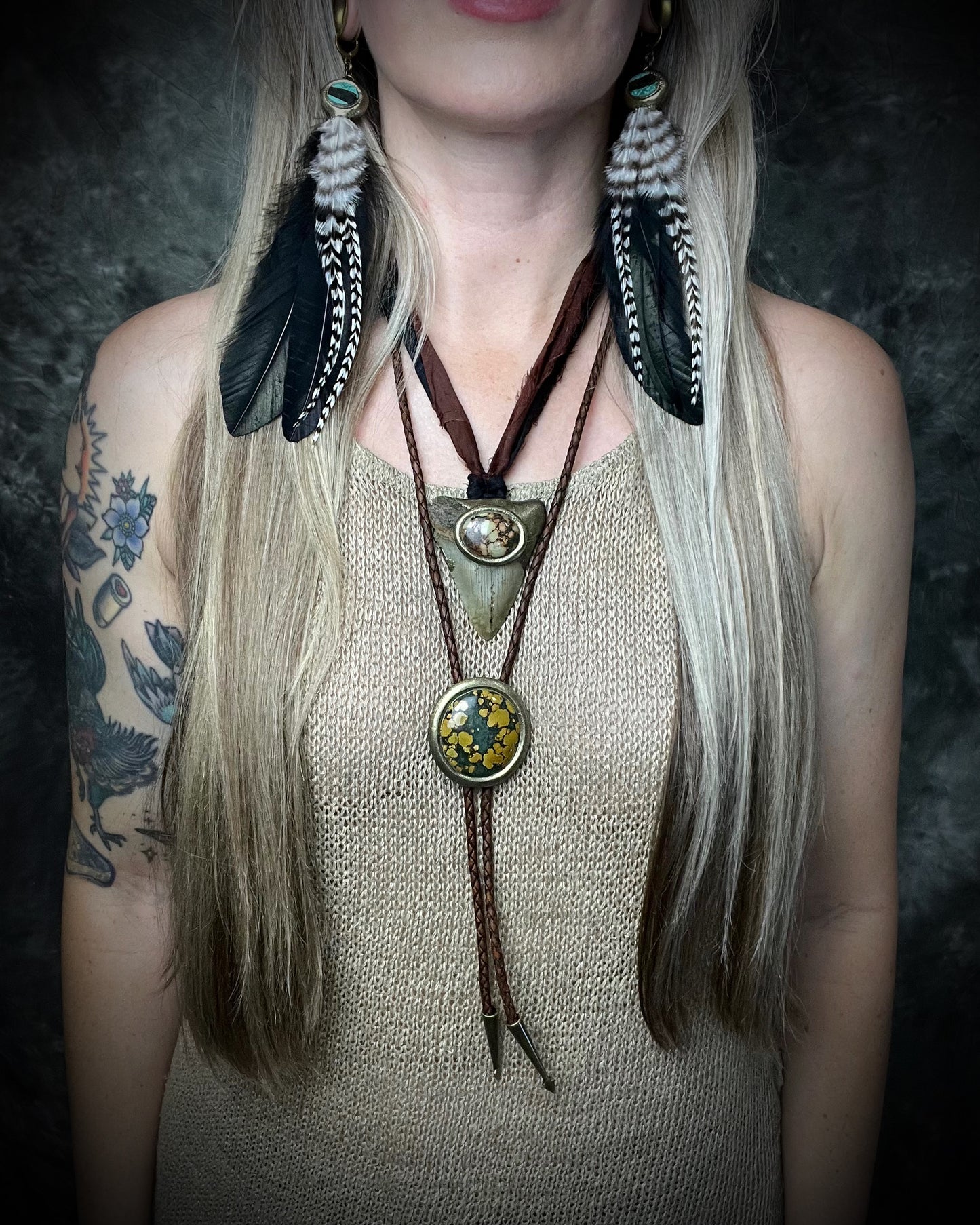 Mossy green and mustard-yellow turquoise bolo tie with natural plume markings, gold finish, brown leather, and gold spade tips.