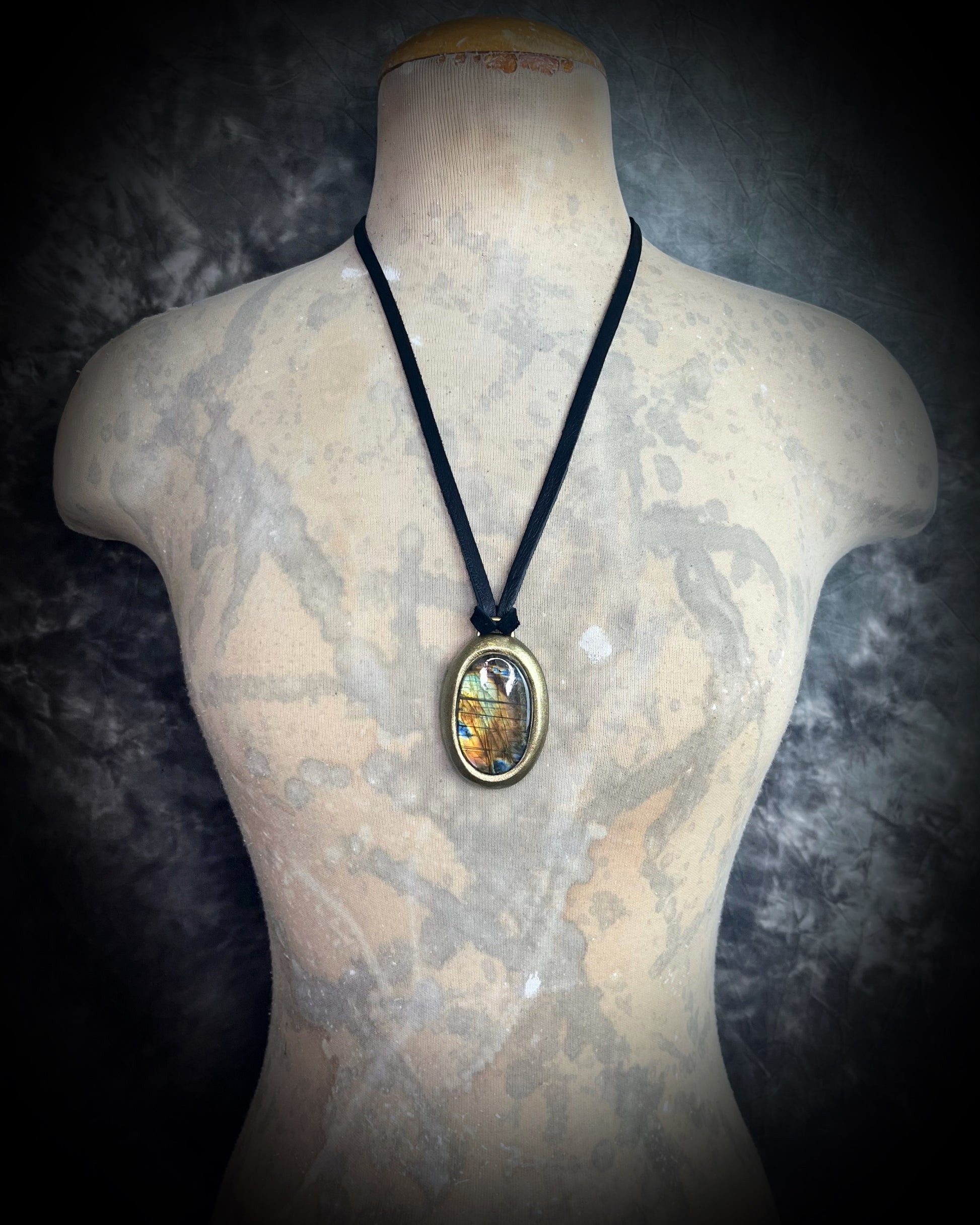 Mystical labradorite necklace on black leather cord, hand-sculpted artisan talisman with raw gemstone pendant, gothic crystal jewelry for spiritual style.