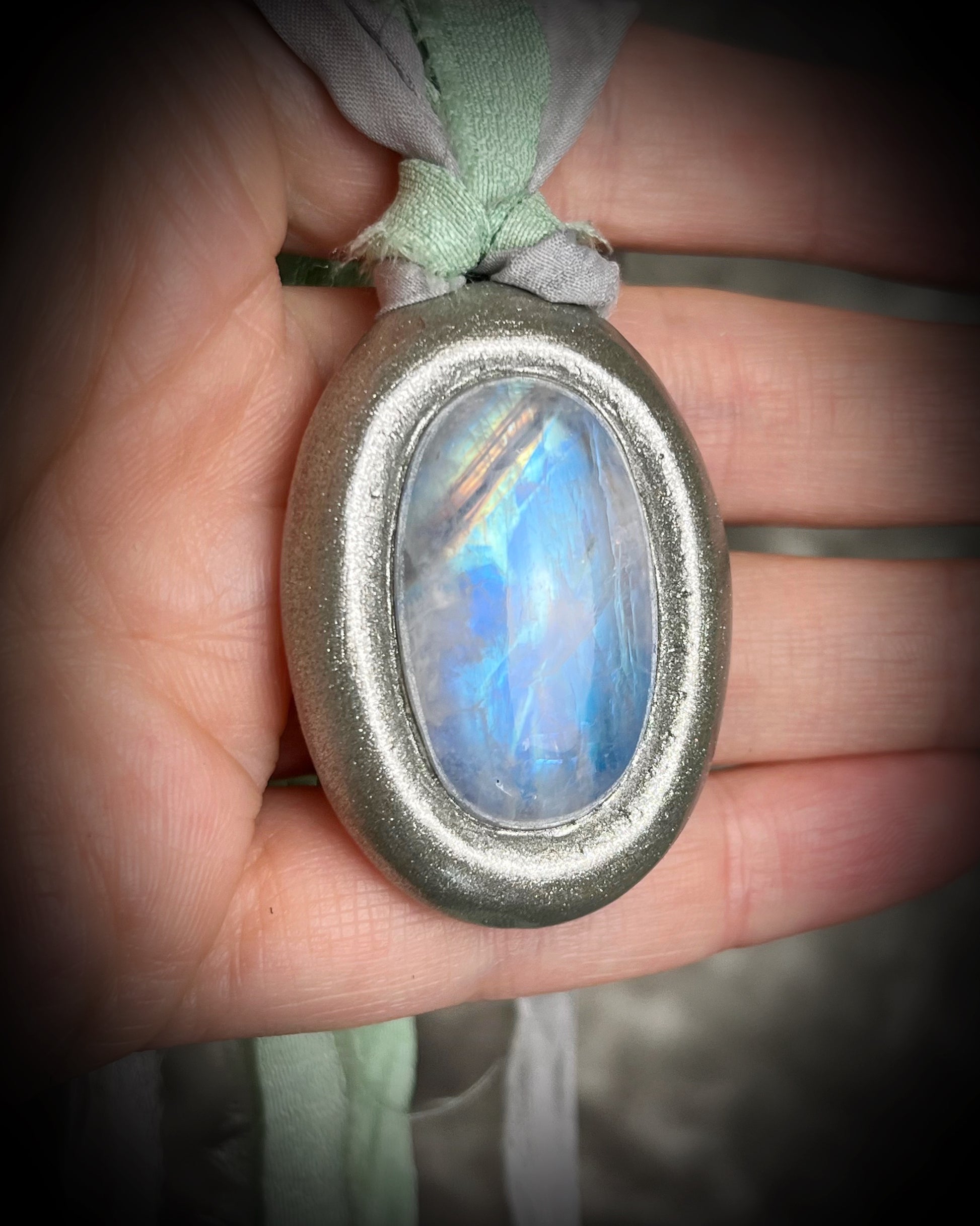 Mystical moonstone oval pendant in silver tone setting on recycled silk cord. Handmade crystal necklace for intuition, divine feminine energy, and spiritual connection. Unique gift for her, gemstone jewelry for meditation or daily wear.