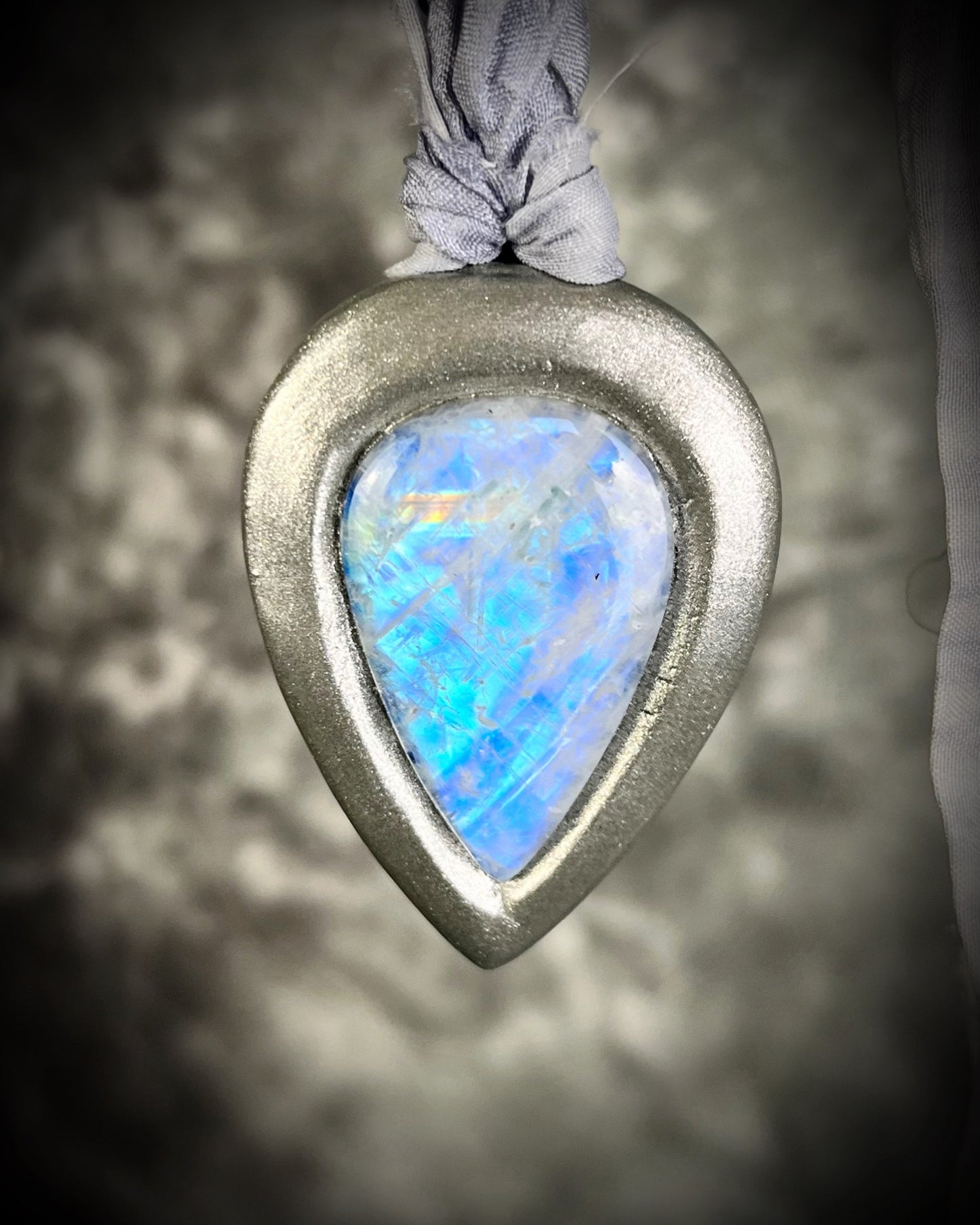 Mystical moonstone teardrop pendant in silver tone setting on recycled silk cord. Handmade crystal necklace for intuition, divine feminine energy, and spiritual connection. Unique gemstone jewelry for meditation, daily wear, or gifting.