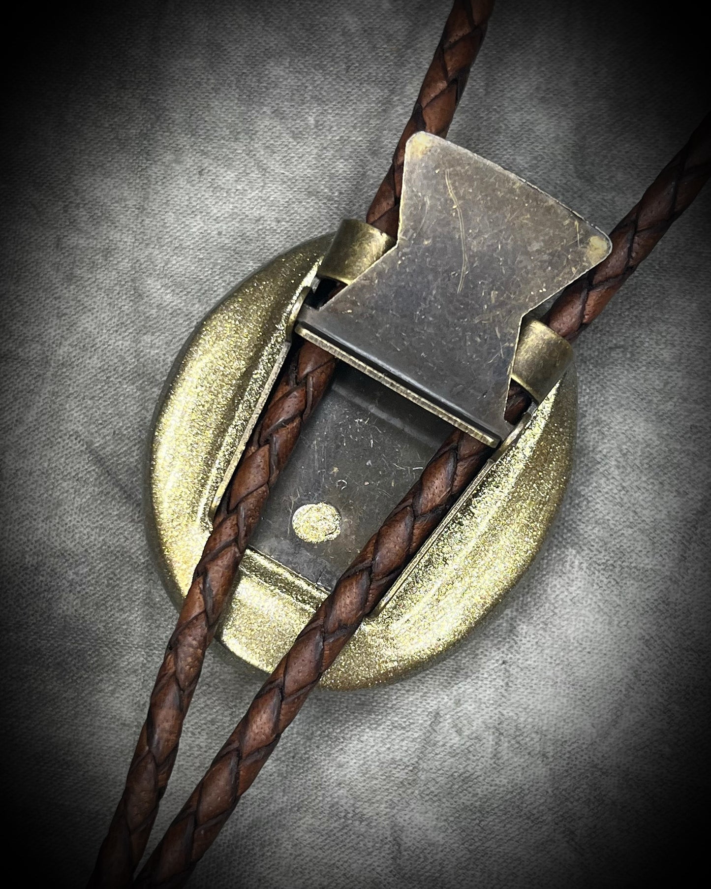 Natural turquoise bolo tie with distinctive double brown stripe resembling claw marks, brown leather, gold finish, and gold spike tips.