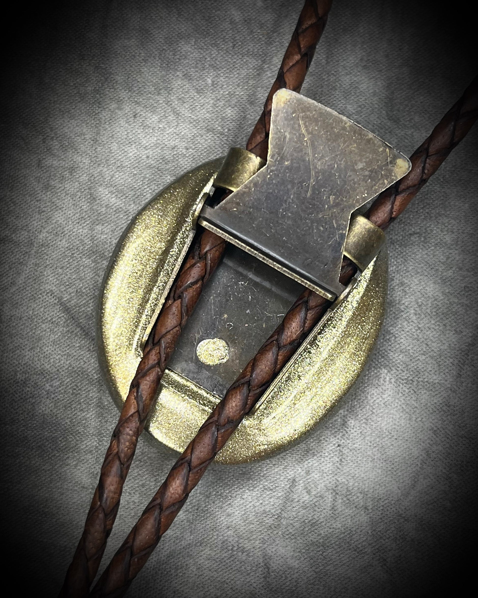 Natural turquoise bolo tie with distinctive double brown stripe resembling claw marks, brown leather, gold finish, and gold spike tips.