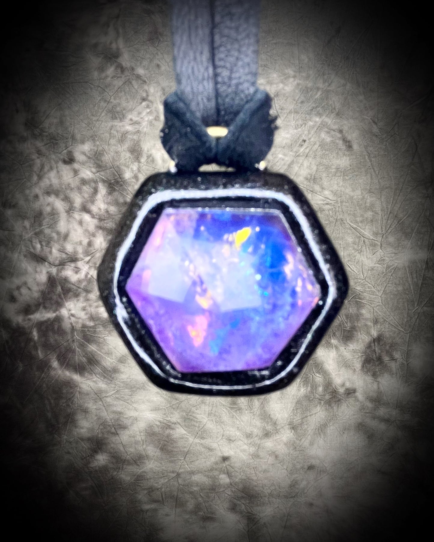 Opalescent amethyst hexagon pendant framed in black on black leather cord — handmade mystical crystal talisman necklace.