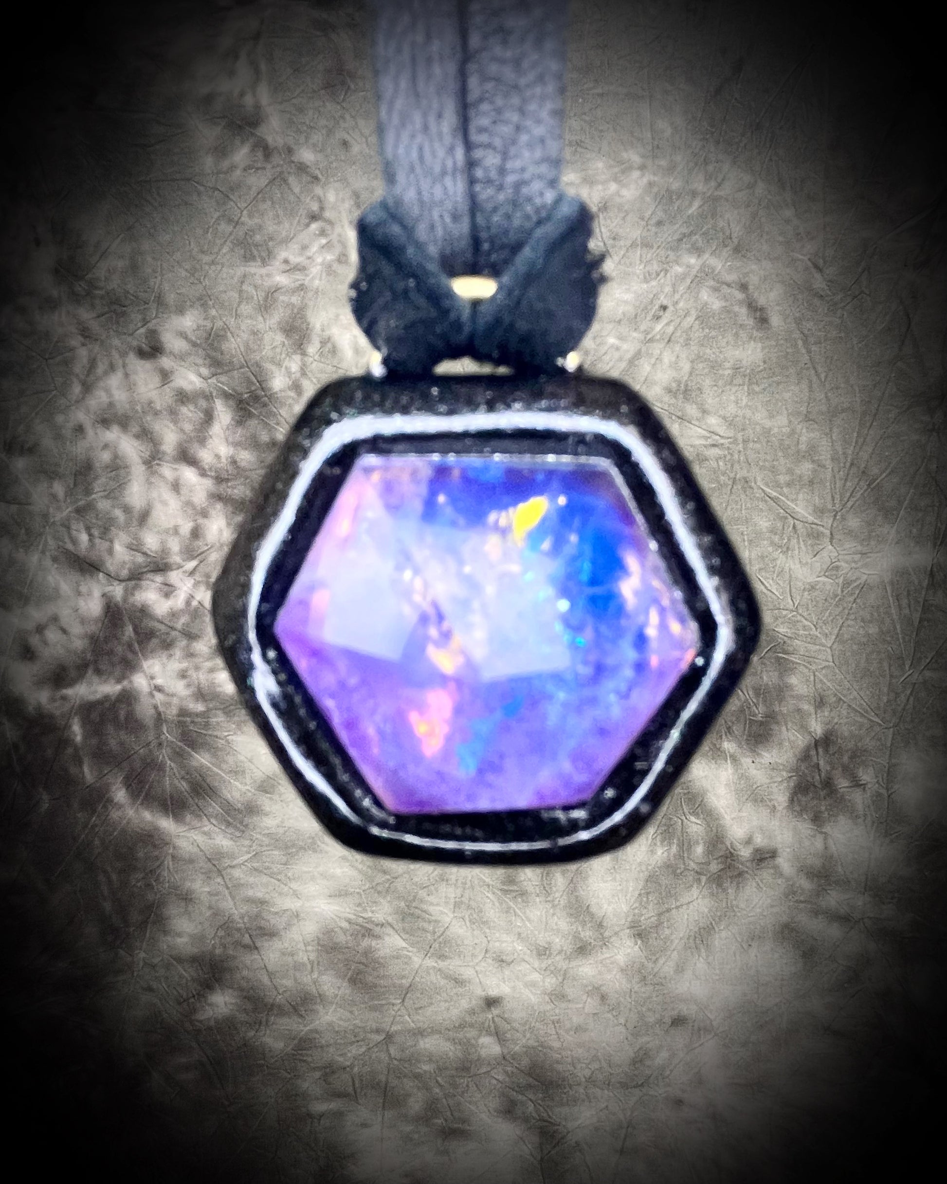 Opalescent amethyst hexagon pendant framed in black on black leather cord — handmade mystical crystal talisman necklace.