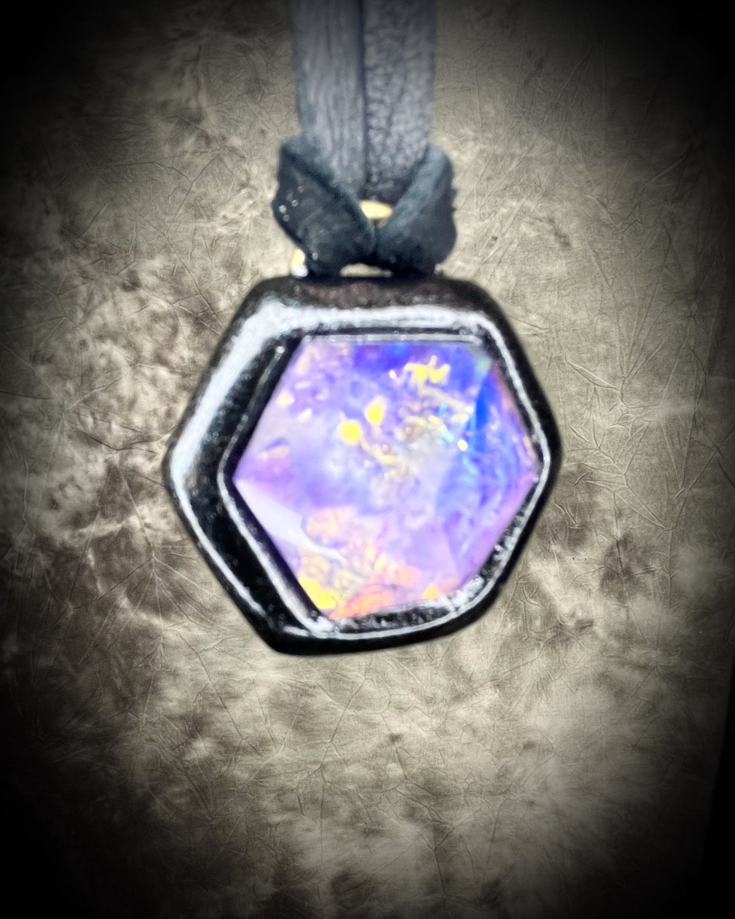 Opalescent amethyst hexagon pendant framed in black on black leather cord — handmade mystical crystal talisman necklace.