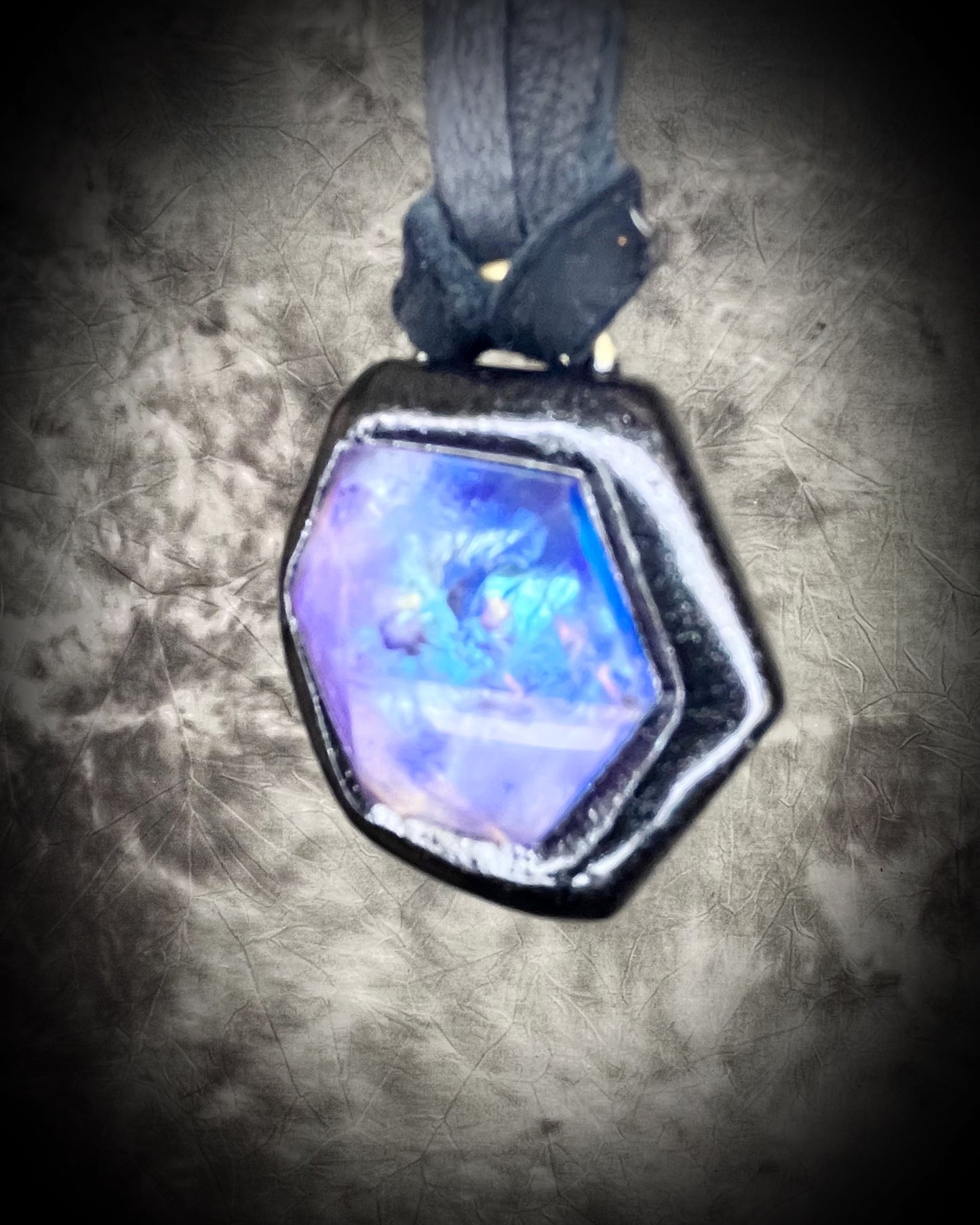 Opalescent amethyst hexagon pendant framed in black on black leather cord — handmade mystical crystal talisman necklace.