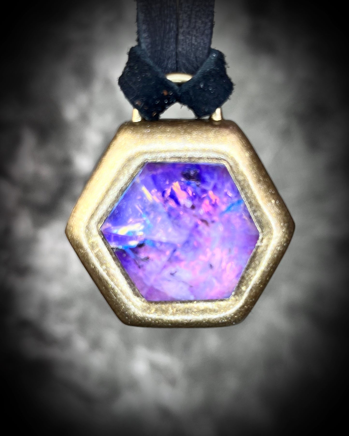 Opalescent amethyst hexagon pendant framed in gold on black leather cord — handmade mystical crystal talisman necklace.