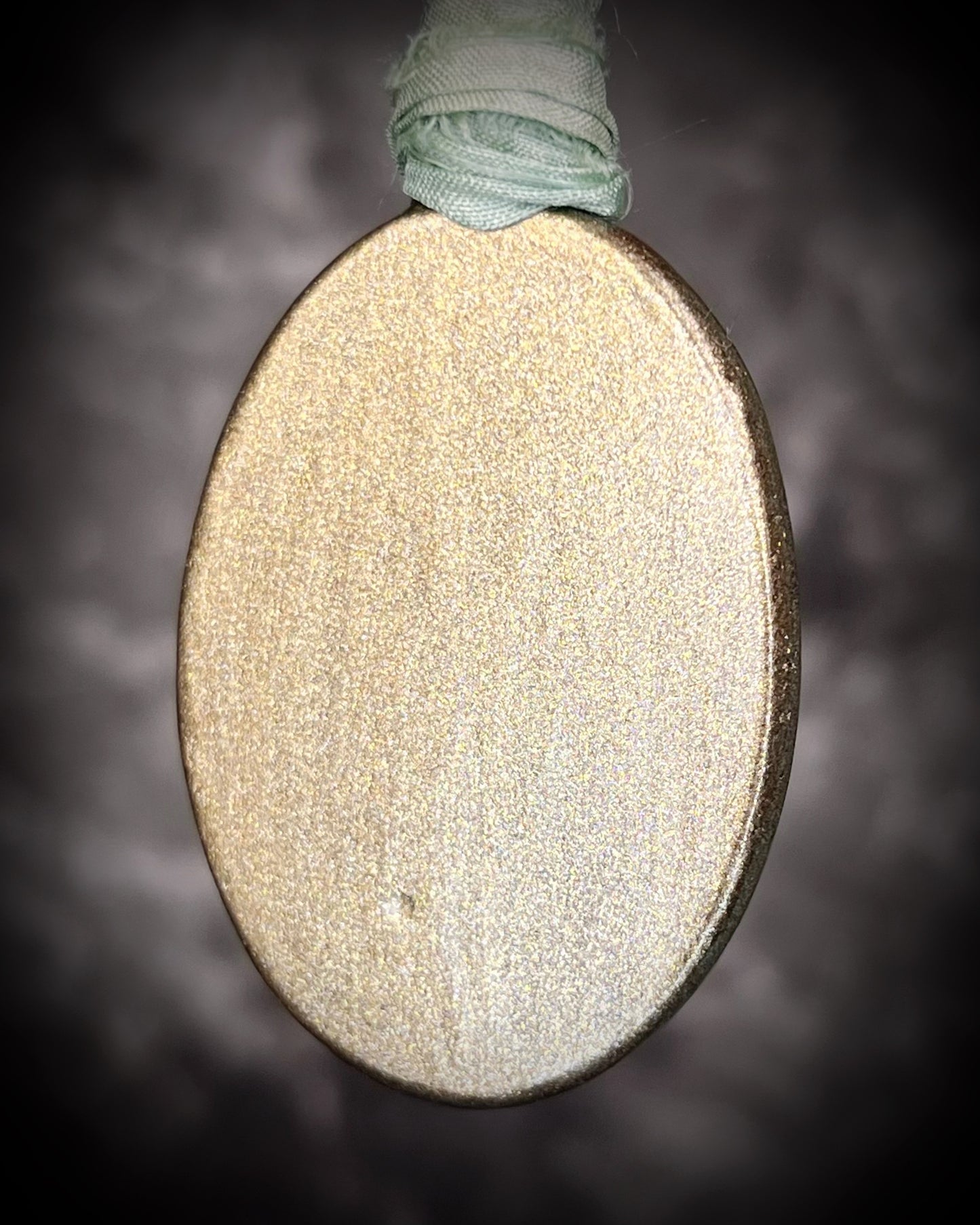 Oval-shaped object with textured surface and string on a dark background