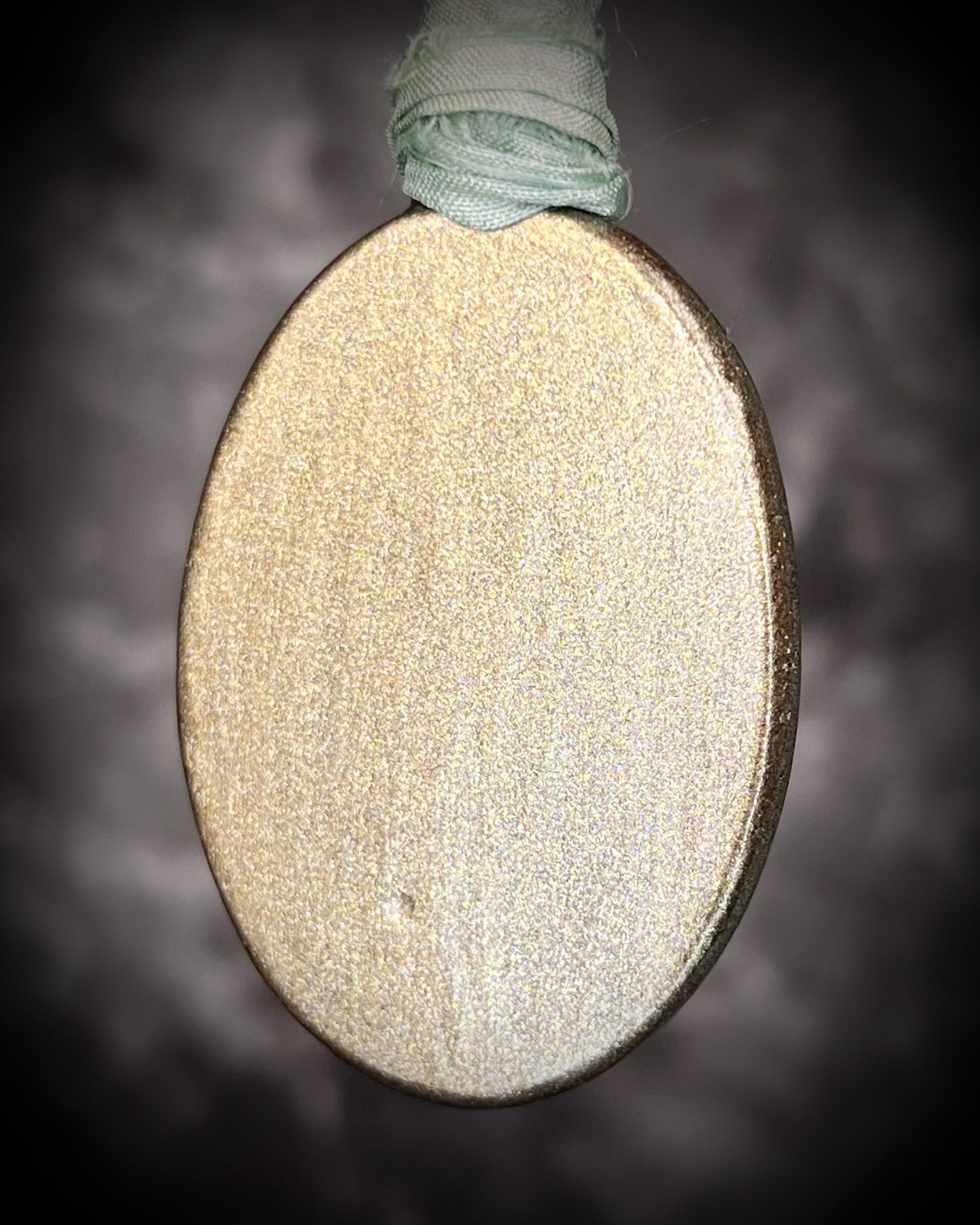 Oval-shaped object with textured surface and string on a dark background