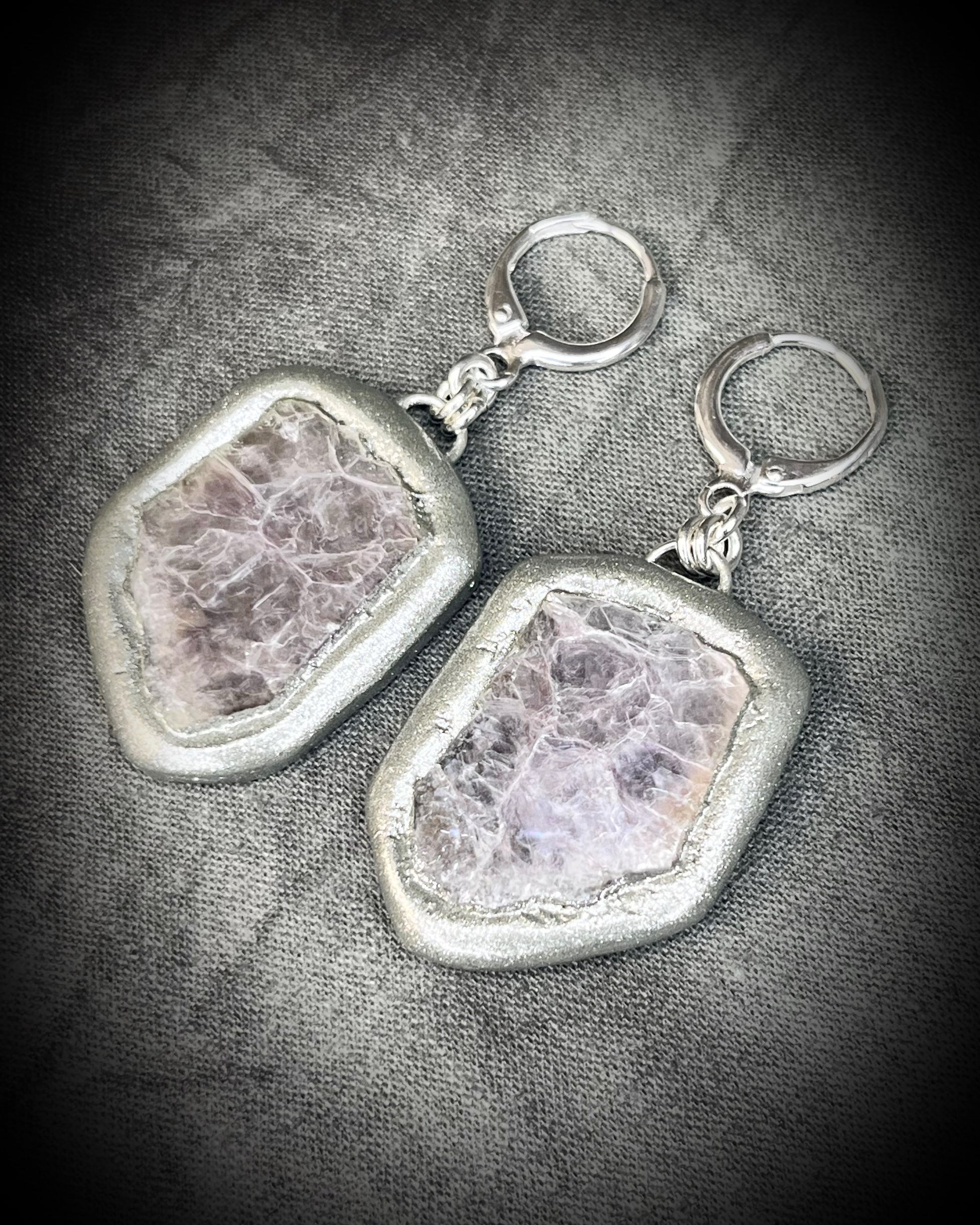 Pair of silver dangle earrings with raw lepidolite crystal gemstones on a dark background. Chunky silver jewelry holiday gift for her. 