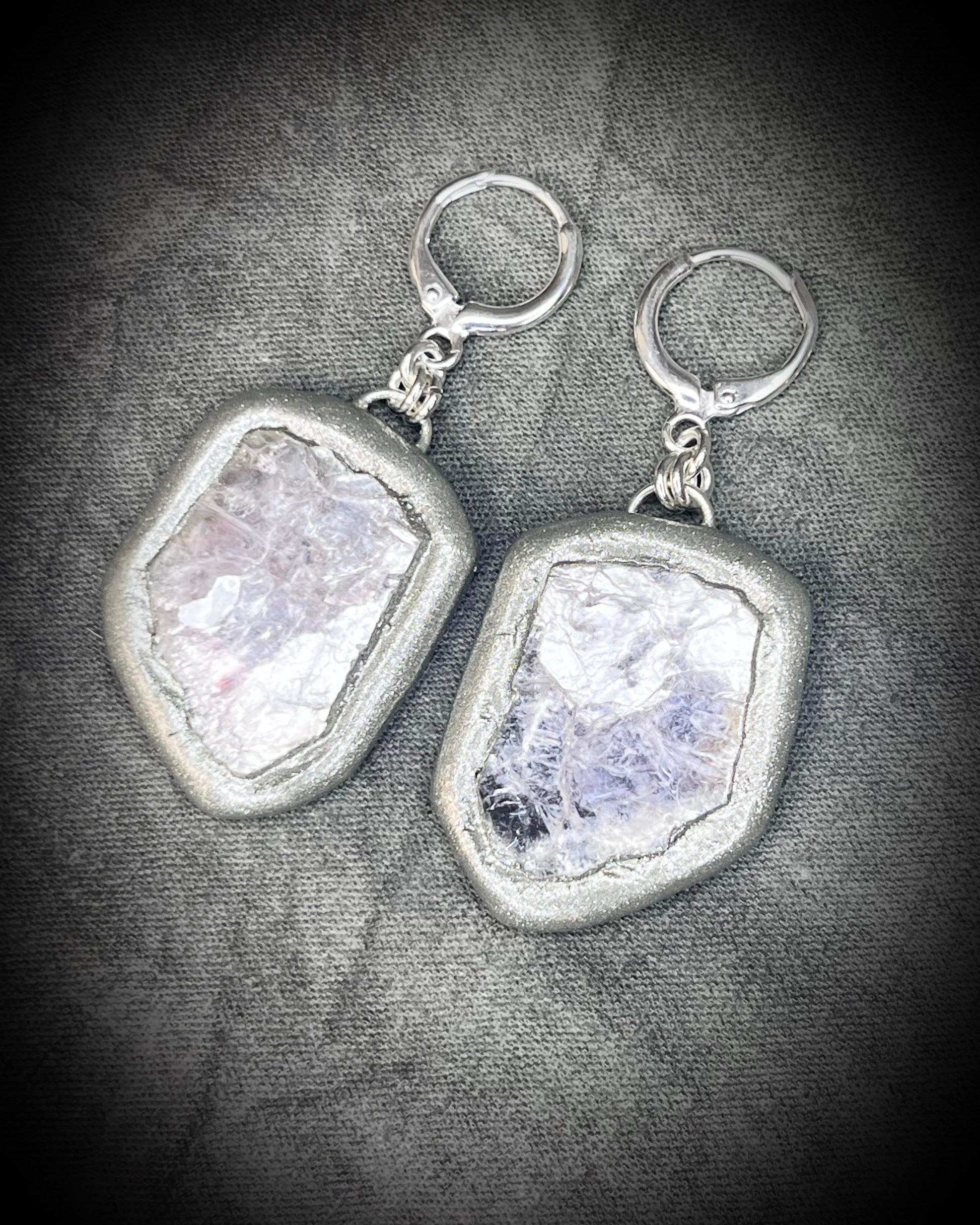 Pair of silver dangle earrings with raw lepidolite crystal gemstones on a dark background. Chunky silver jewelry holiday gift for her. 