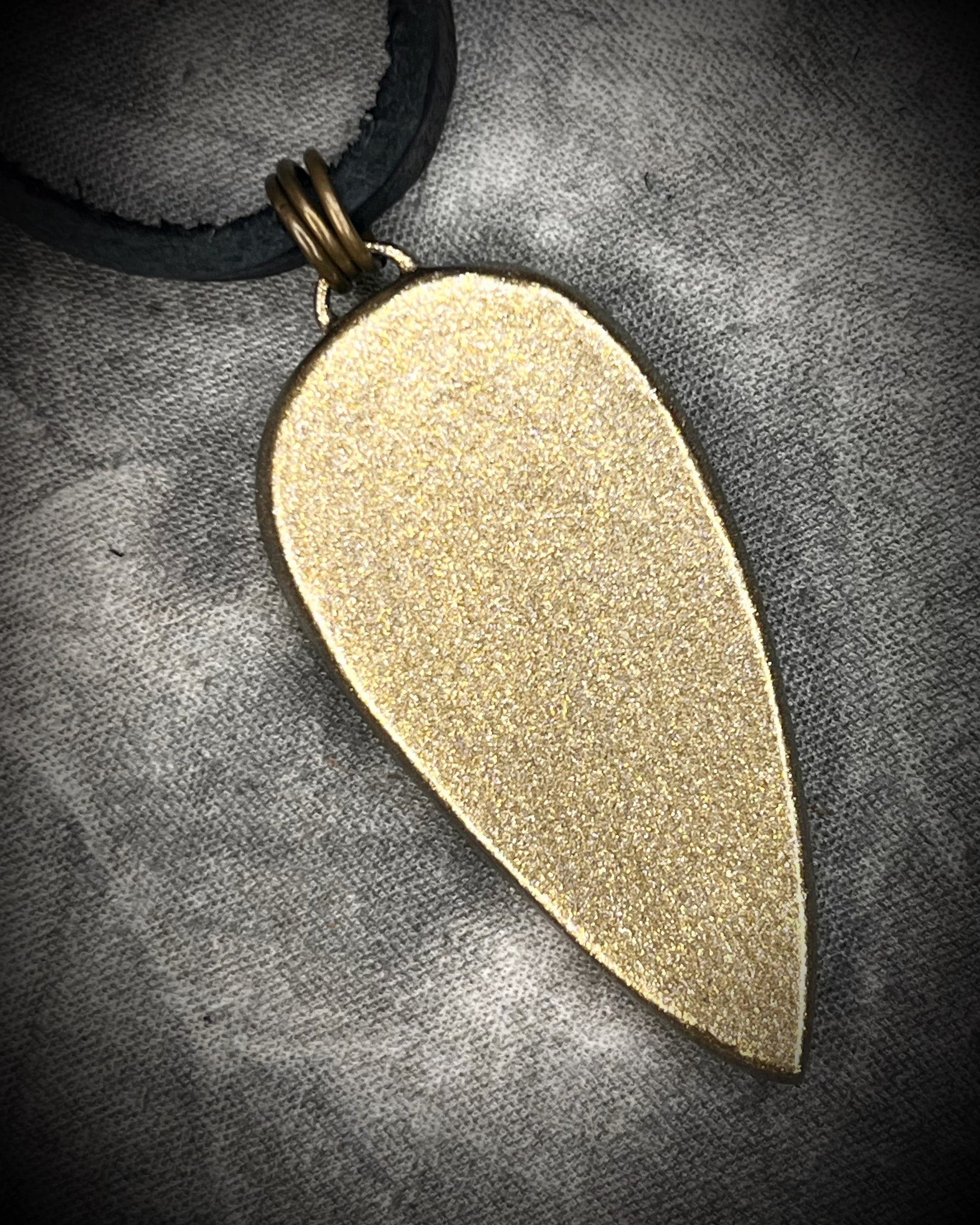 Petrified palm root necklace, teardrop shaped and set in a gold finish. Fossilized wood pendant hung from black leather for a protective and grounding vibe. 