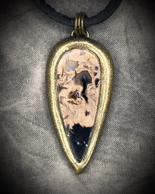Petrified palm root necklace, teardrop shaped and set in a gold finish. Fossilized wood pendant hung from black leather for a protective and grounding vibe. 
