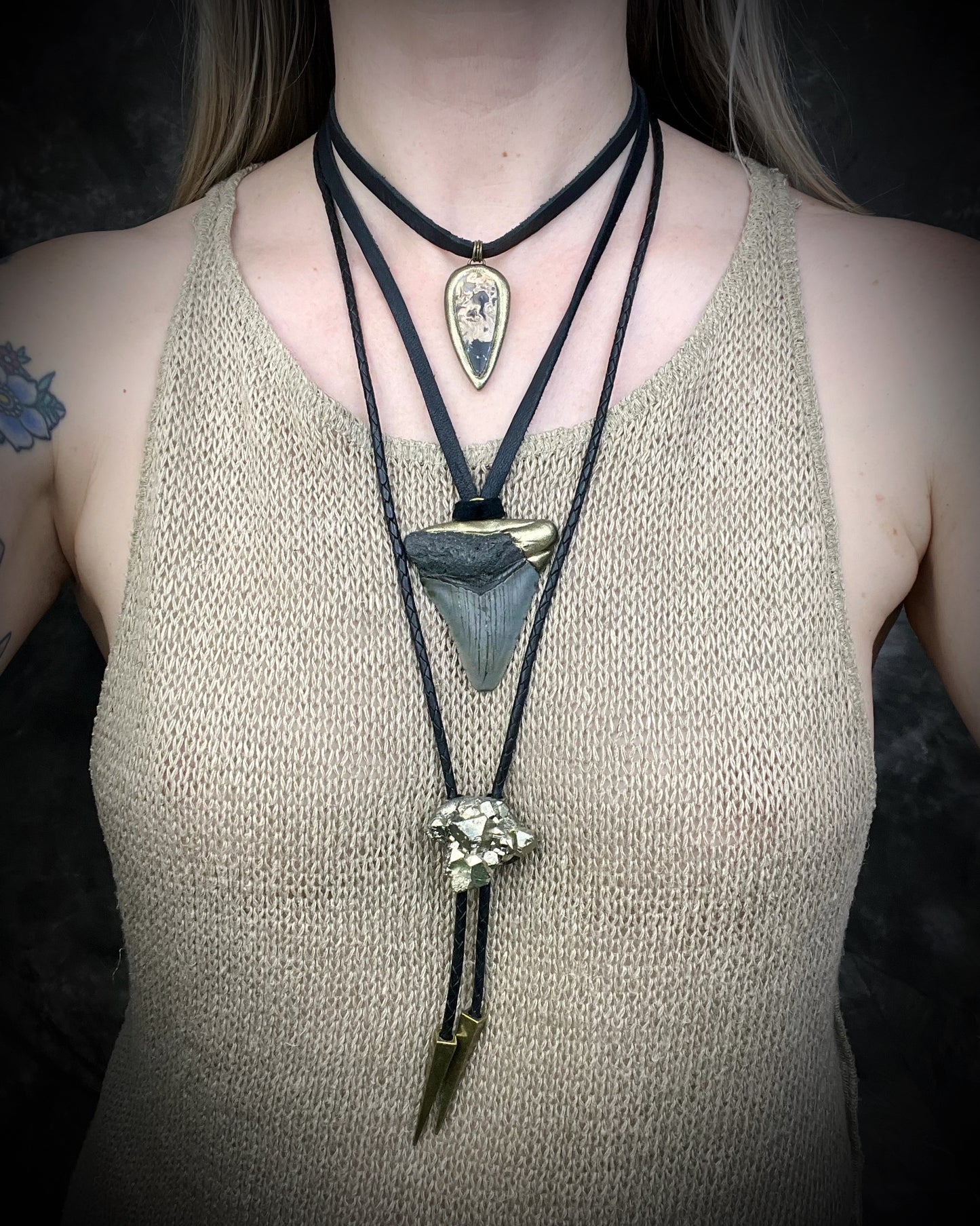 Petrified palm root necklace, teardrop shaped and set in a gold finish. Fossilized wood pendant hung from black leather for a protective and grounding vibe. 