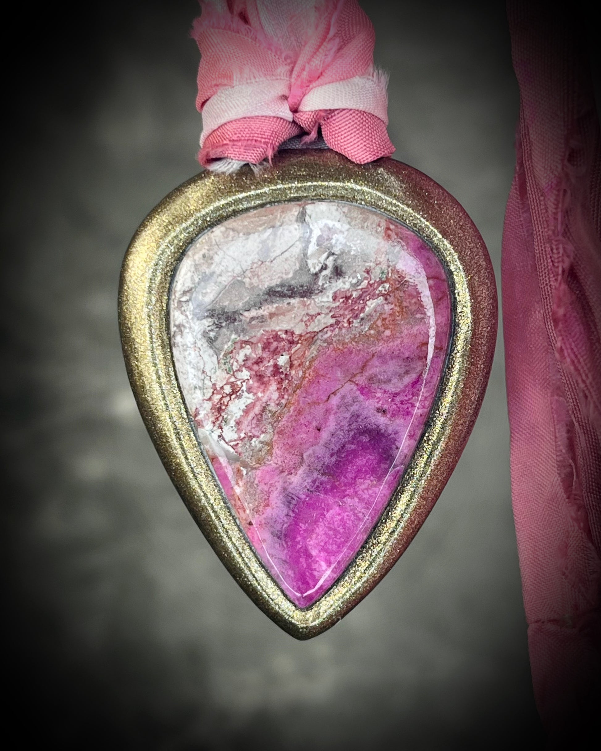 Pink calcite teardrop talisman with sculpted gold finish and ombre pink recycled silk ties. Handmade by Become Spellbound.