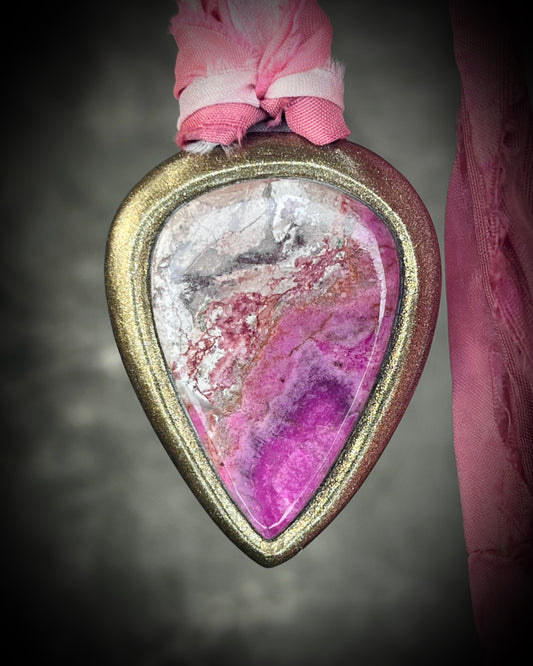 Pink calcite teardrop talisman with sculpted gold finish and ombre pink recycled silk ties. Handmade by Become Spellbound.
