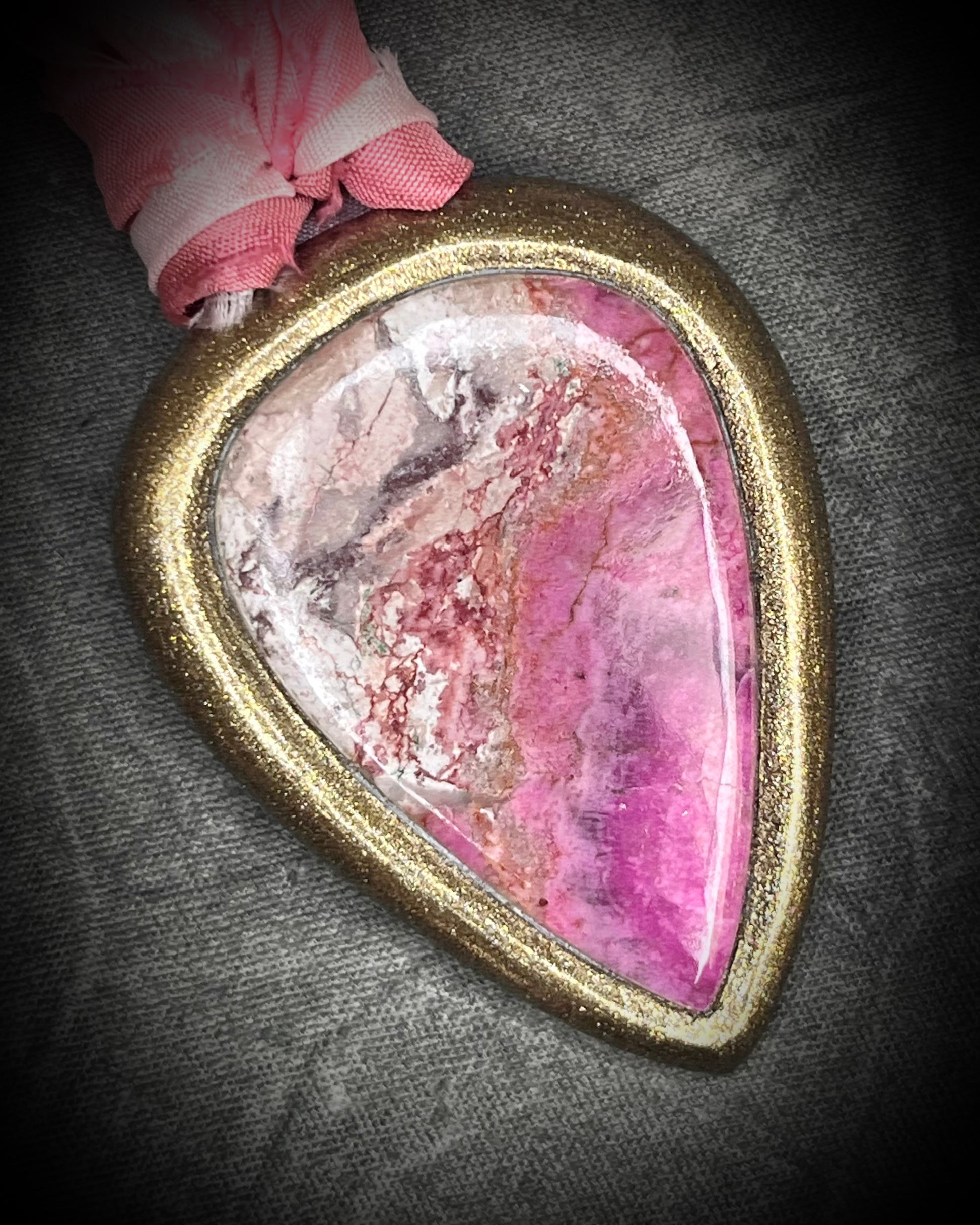 Pink calcite teardrop talisman with sculpted gold finish and ombre pink recycled silk ties. Handmade by Become Spellbound.