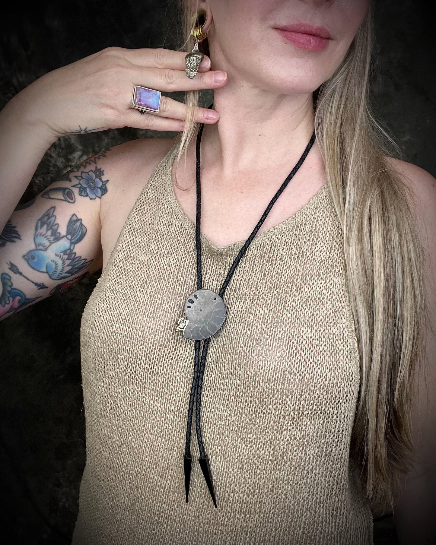 Pink moonstone sterling silver ring with luminous magenta tones and iridescent flash, celestial gemstone jewelry. Worn here with crystal earrings and a fossil bolo tie.