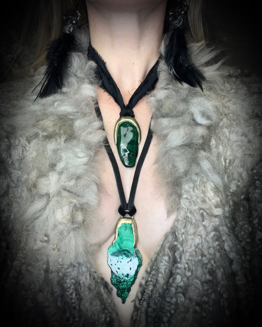 Polished malachite freeform crystal with natural green bands in a sculptural gold-finish talisman setting on black recycled silk, handmade by Become Spellbound in Baltimore, Maryland.