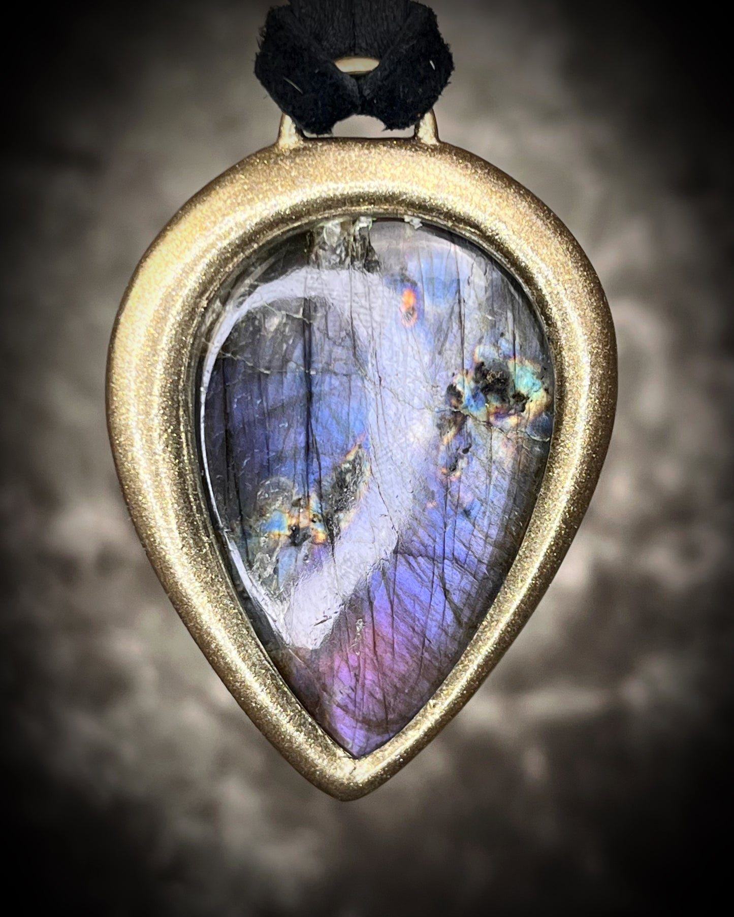 Purple flash moody violet labradorite teardrop crystal necklace in a gold finish on black leather. Handmade mystical jewelry gift for her. 