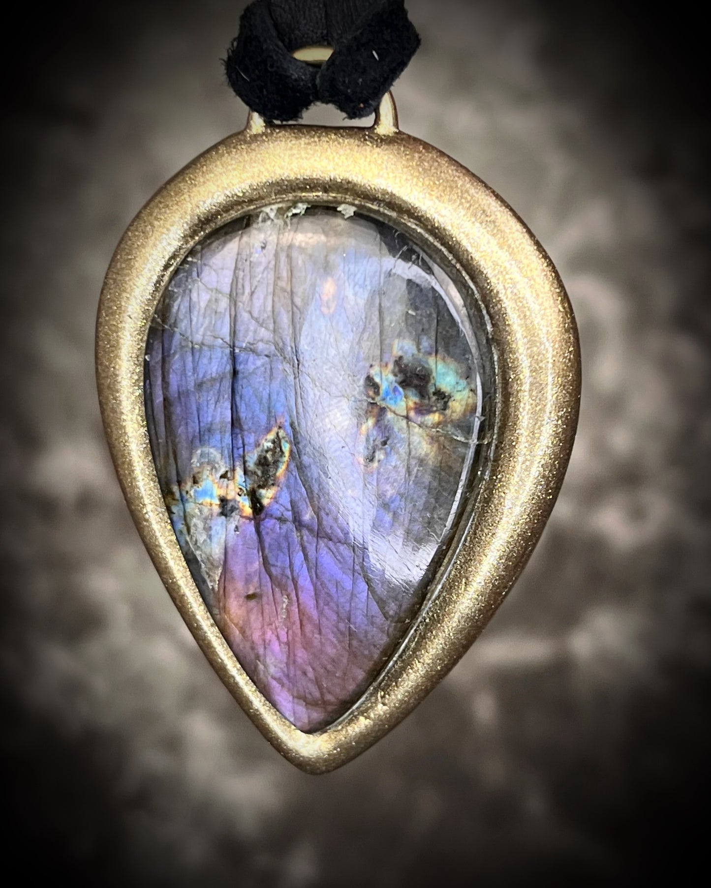 Purple flash moody violet labradorite teardrop crystal necklace in a gold finish on black leather. Handmade mystical jewelry gift for her. 