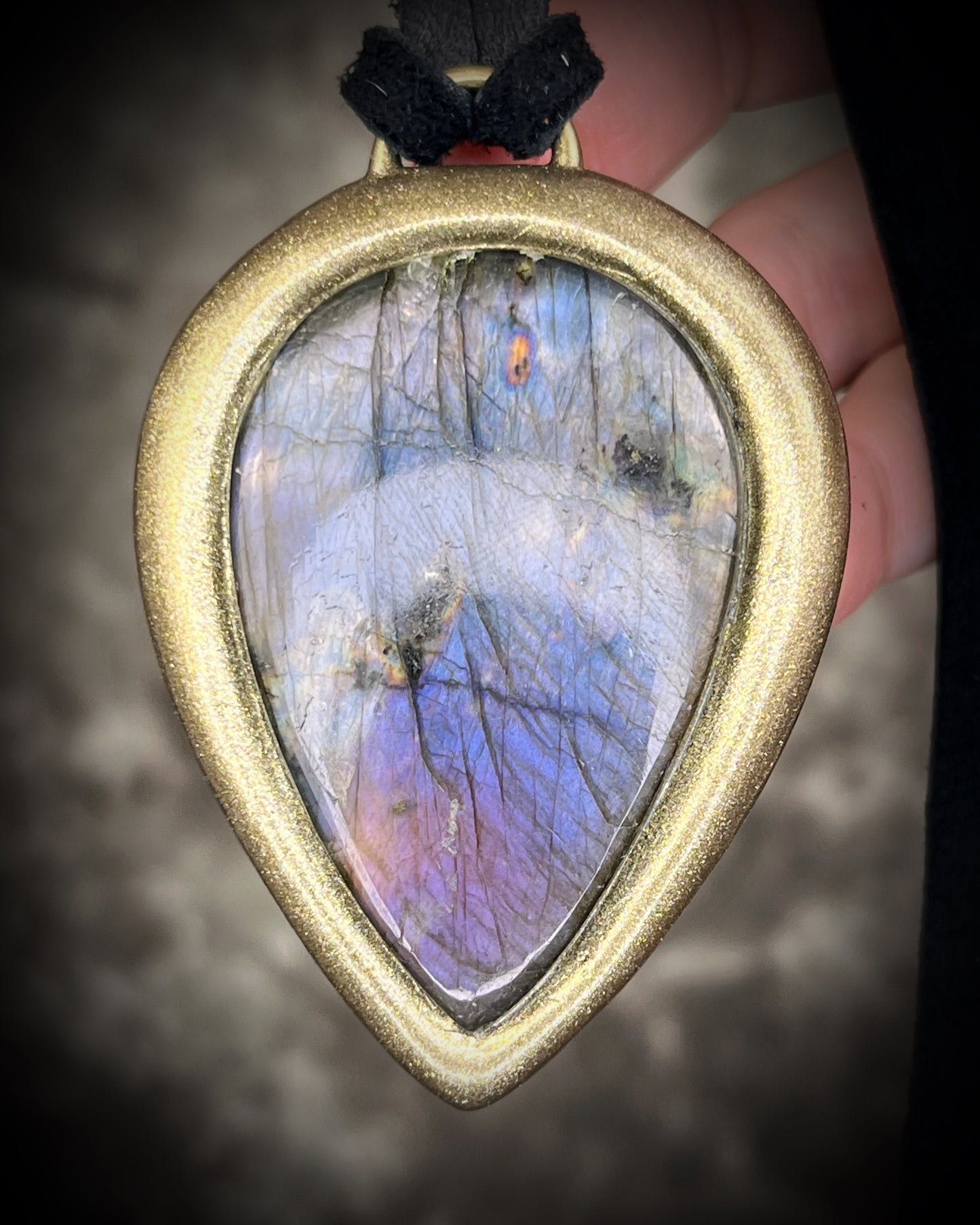 Purple flash moody violet labradorite teardrop crystal necklace in a gold finish on black leather. Handmade mystical jewelry gift for her.  