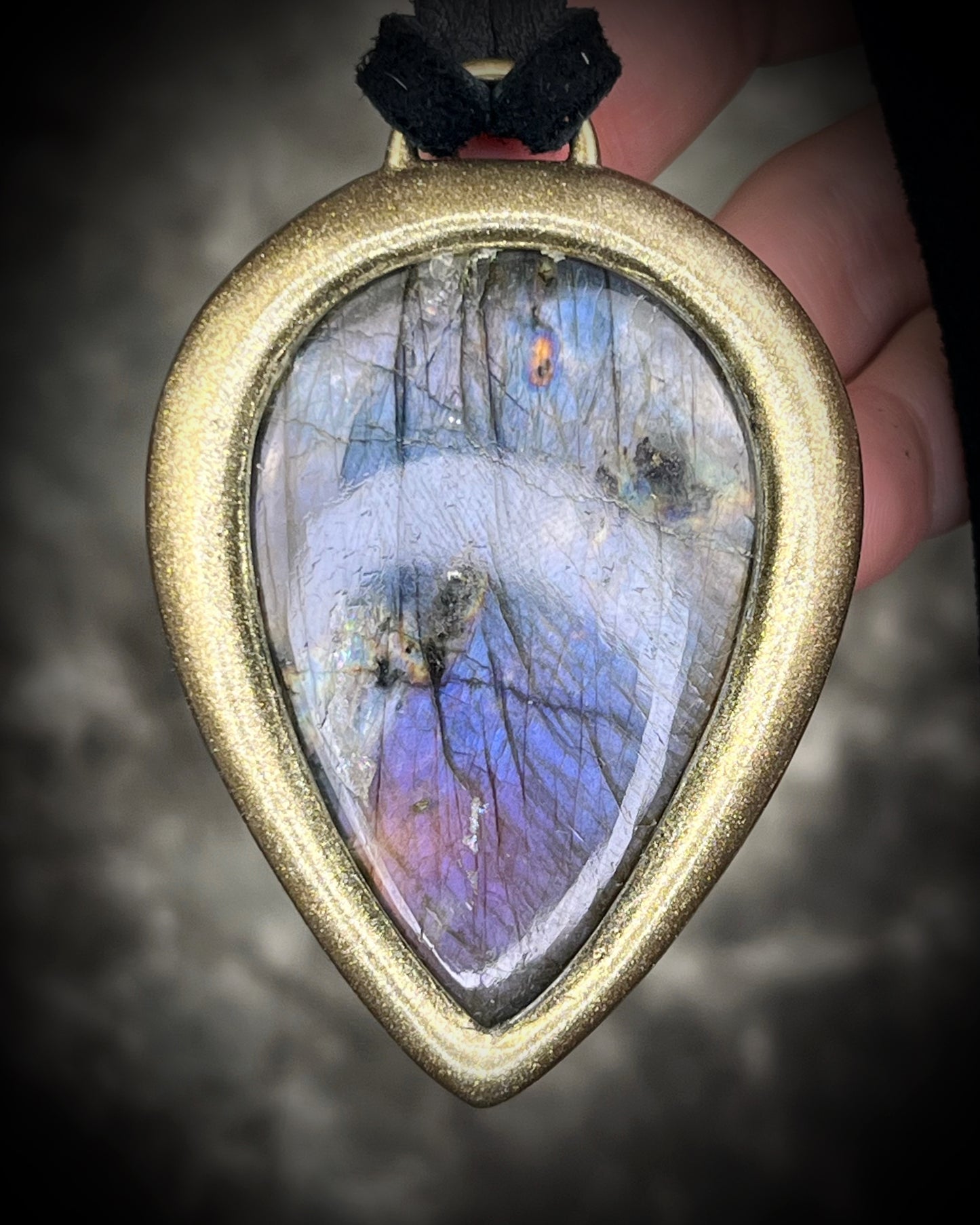 Purple flash moody violet labradorite teardrop crystal necklace in a gold finish on black leather. Handmade mystical jewelry gift for her.  