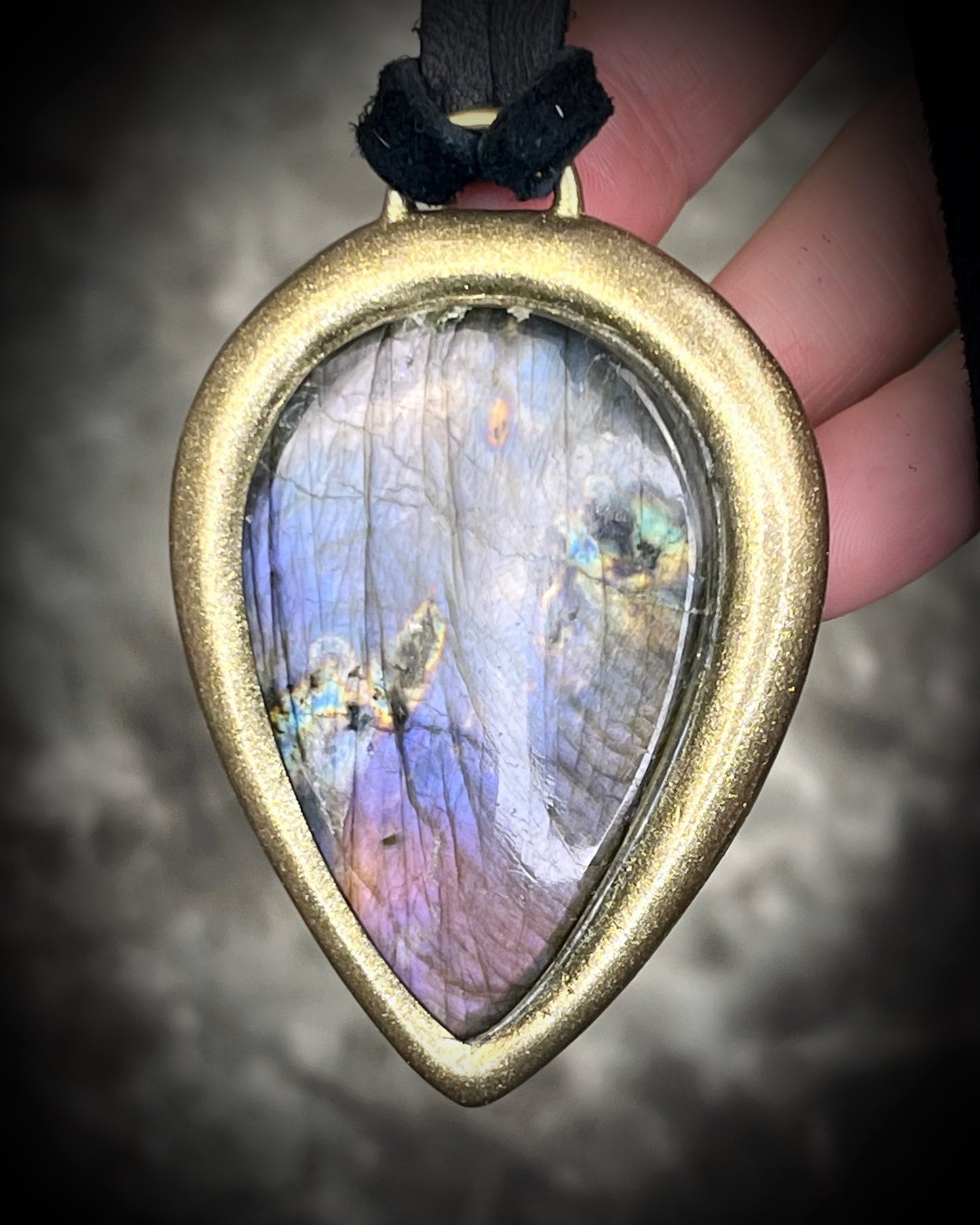 Purple flash moody violet labradorite teardrop crystal necklace in a gold finish on black leather. Handmade mystical jewelry gift for her. 