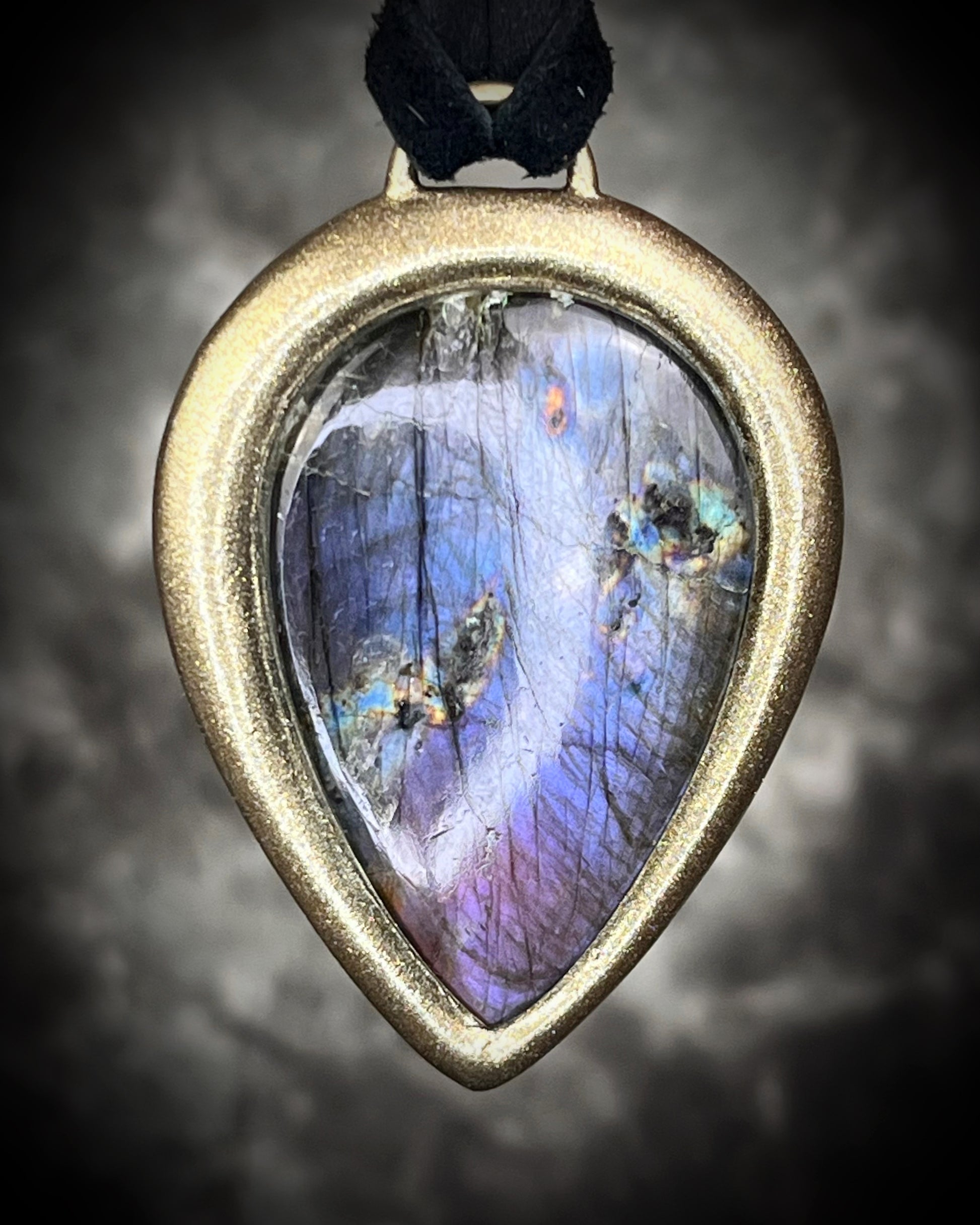 Purple flash moody violet labradorite teardrop crystal necklace in a gold finish on black leather. Handmade mystical jewelry gift for her.  