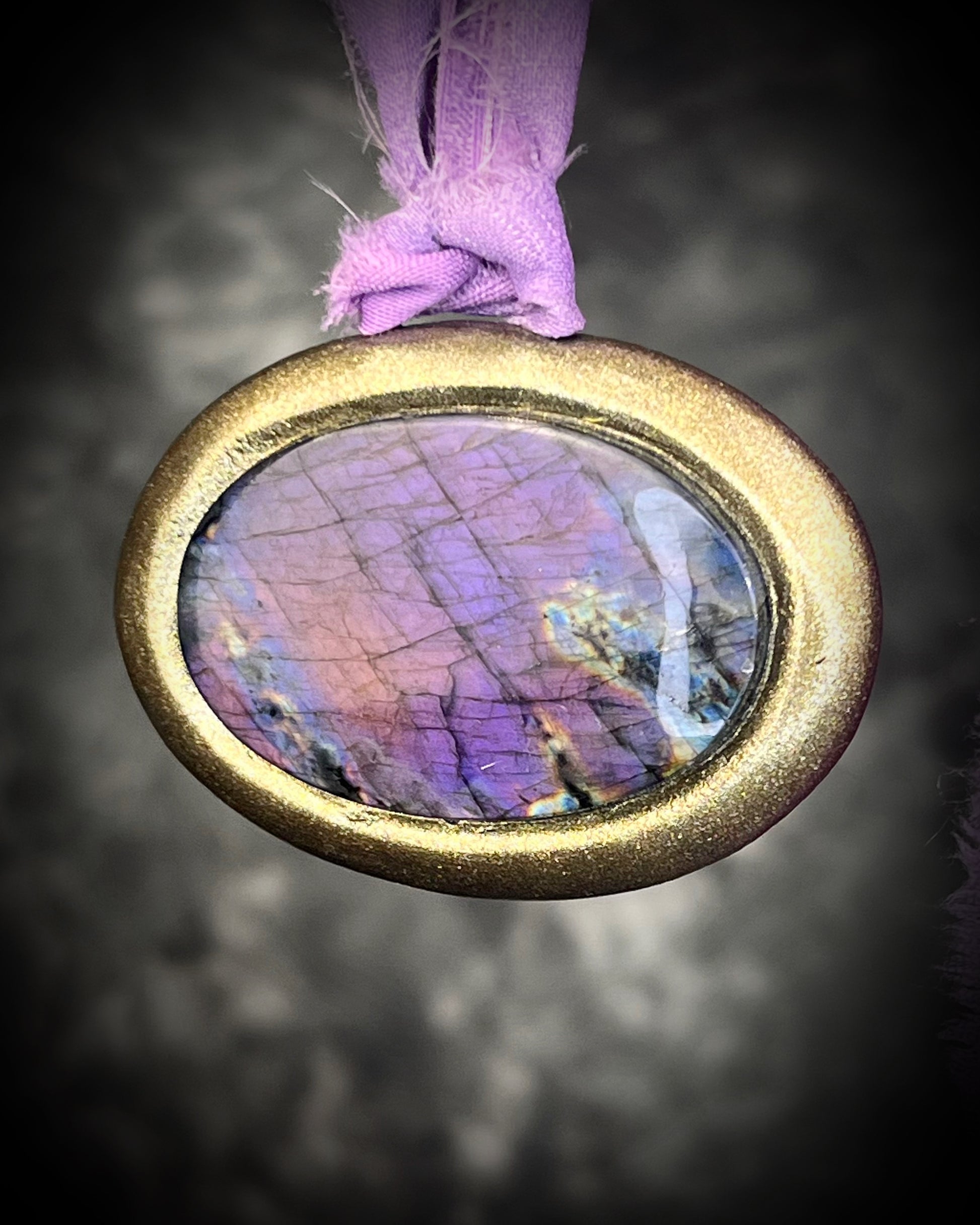 Rare purple flash labradorite talisman with sculpted gold finish and lilac recycled silk ties, handmade by Become Spellbound, Baltimore Magazine Best of Baltimore 2026 Jewelry winner.
