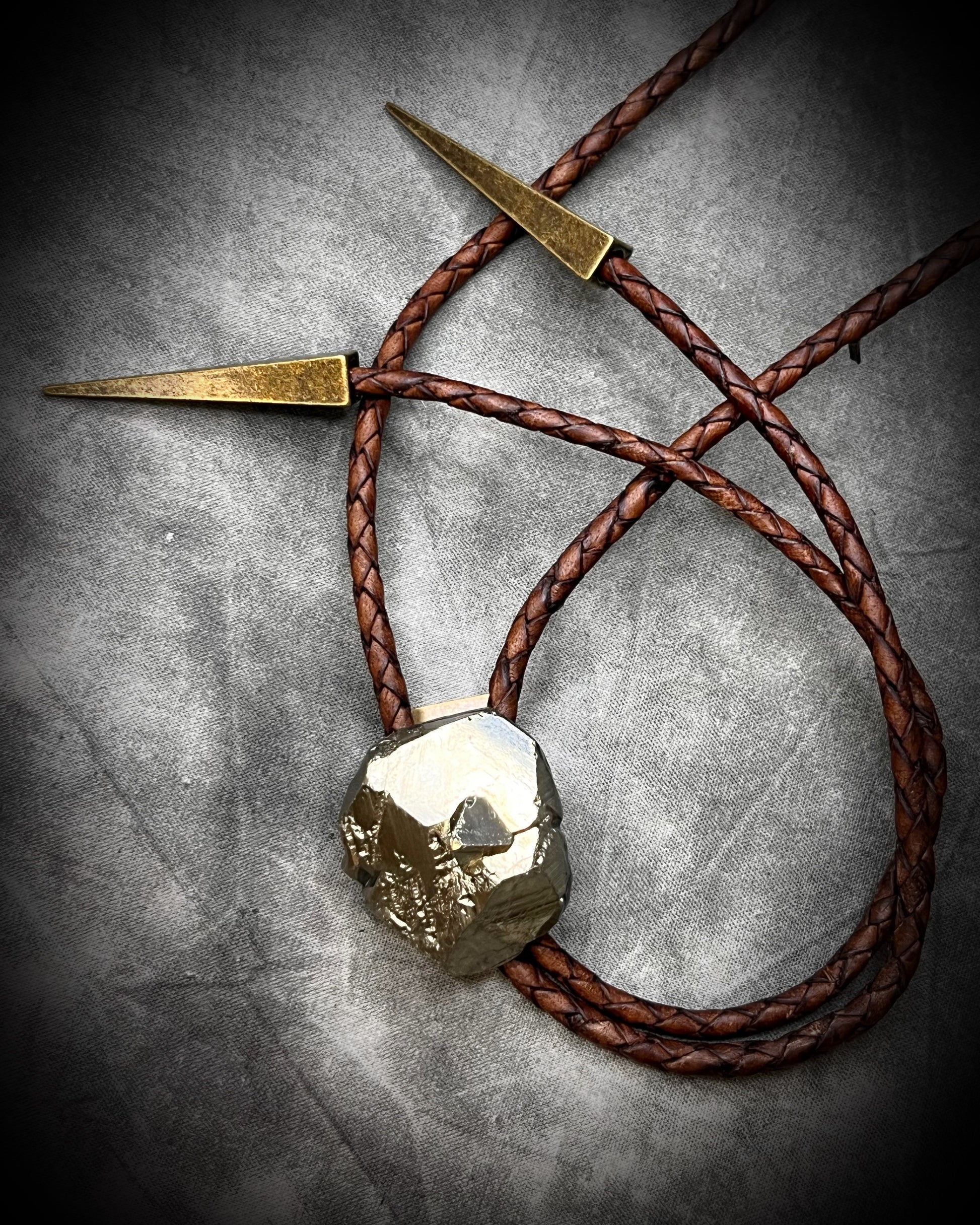 Raw Pyrite gemstone Bolo tie set in an invisible finish and mounted on earthy brown leather. A talisman for ambition, success, and manifestation. Western 2026 jewelry trend bolo. 
