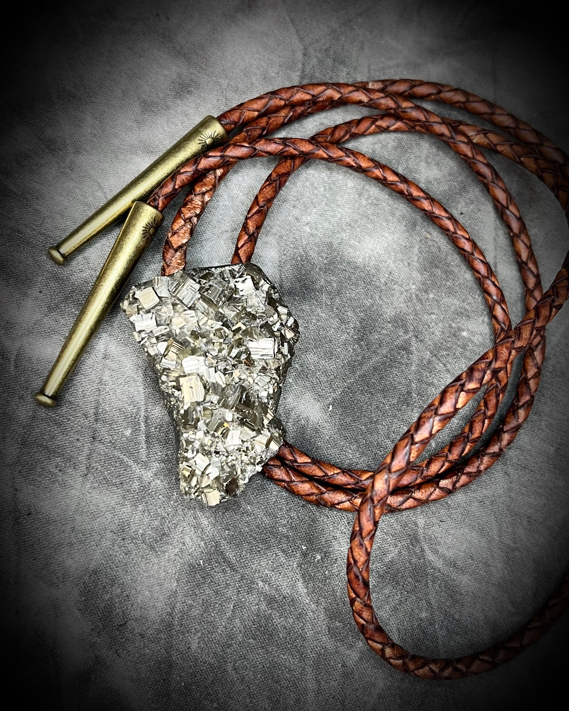Raw Pyrite gemstone Bolo tie set in an invisible finish and mounted on earthy brown leather. A talisman for ambition, success, and manifestation for the holidays and new year. Perfect gift for him!