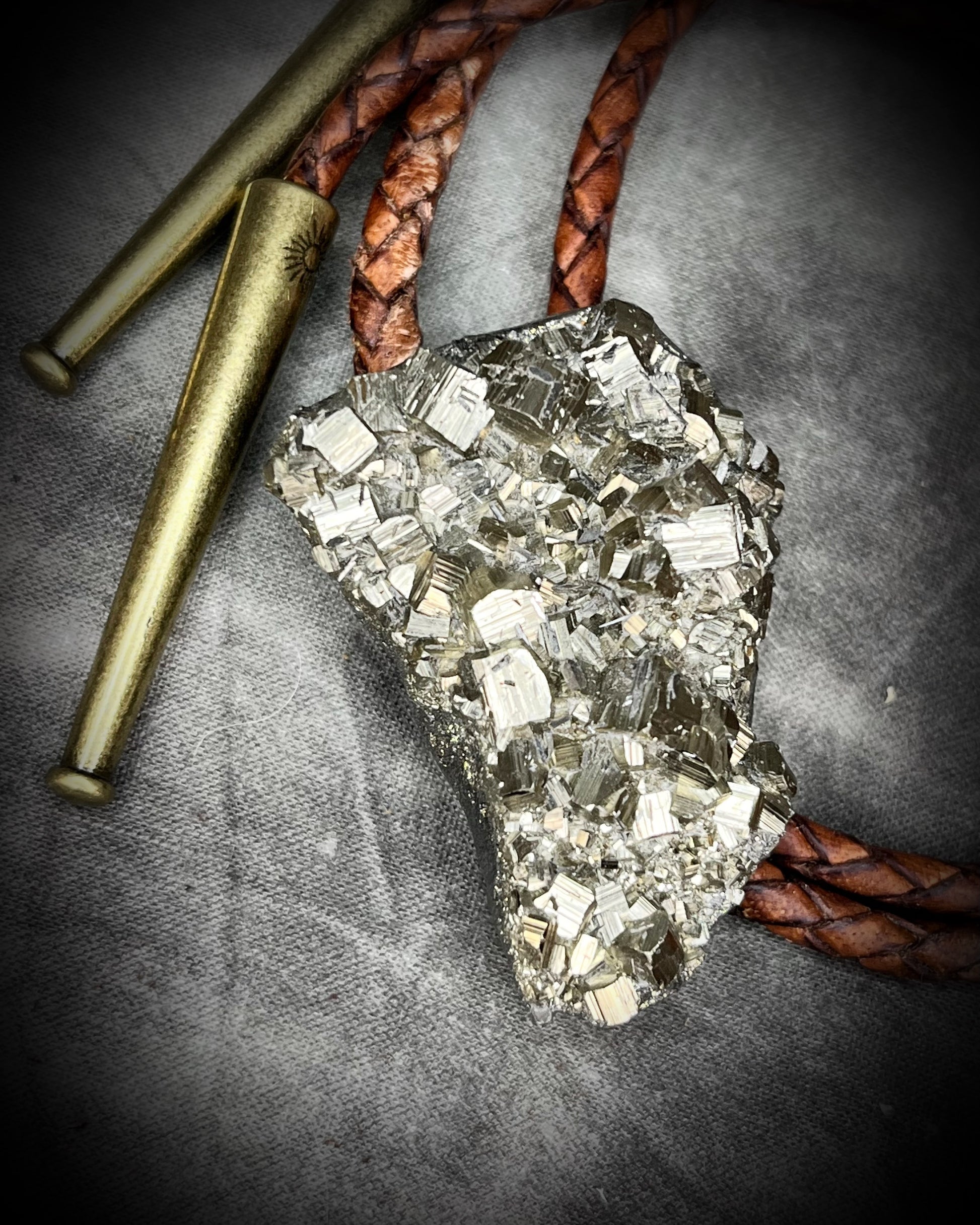 Raw Pyrite gemstone Bolo tie set in an invisible finish and mounted on earthy brown leather. A talisman for ambition, success, and manifestation for the holidays and new year. Perfect gift for him!