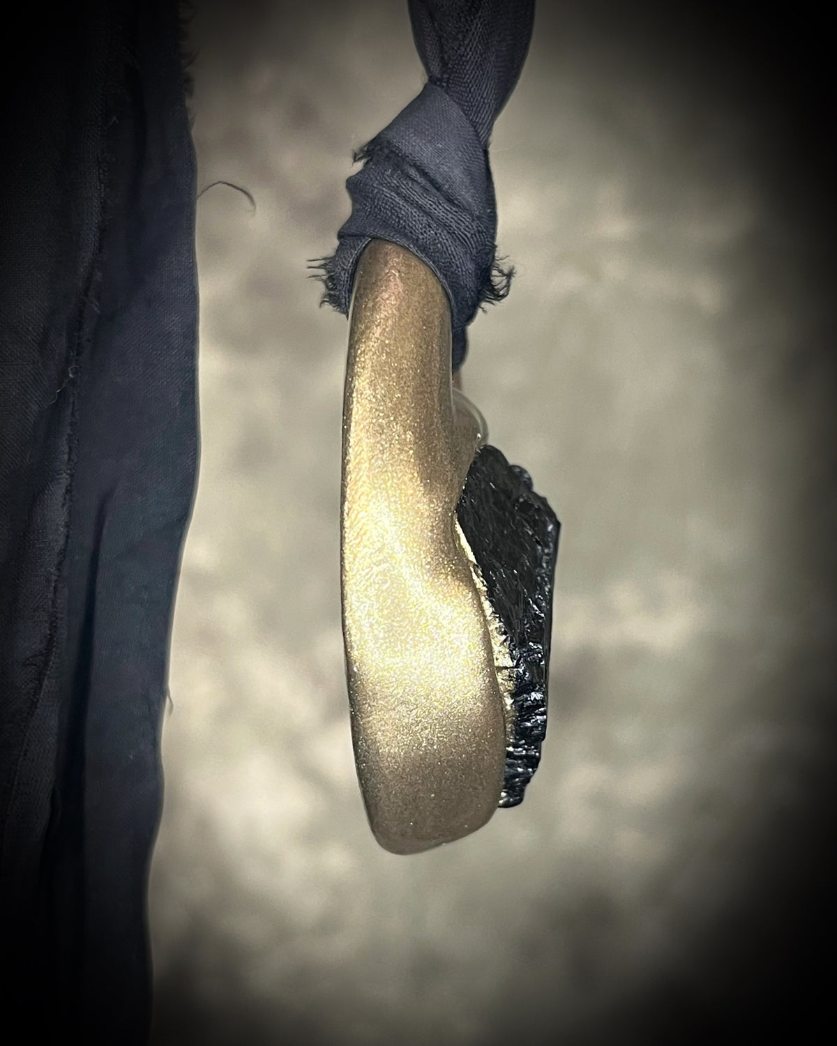 Raw black tourmaline chunk protection talisman with gold finish on black recycled silk, handmade by Become Spellbound in Baltimore, Maryland. 