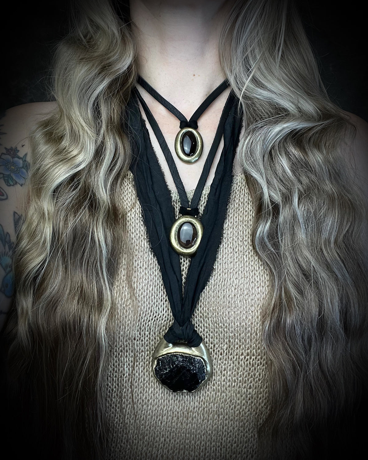 Raw black tourmaline chunk protection talisman with gold finish on black recycled silk, handmade by Become Spellbound in Baltimore, Maryland. Worn here layered with smoky quartz protection talisman necklaces. 